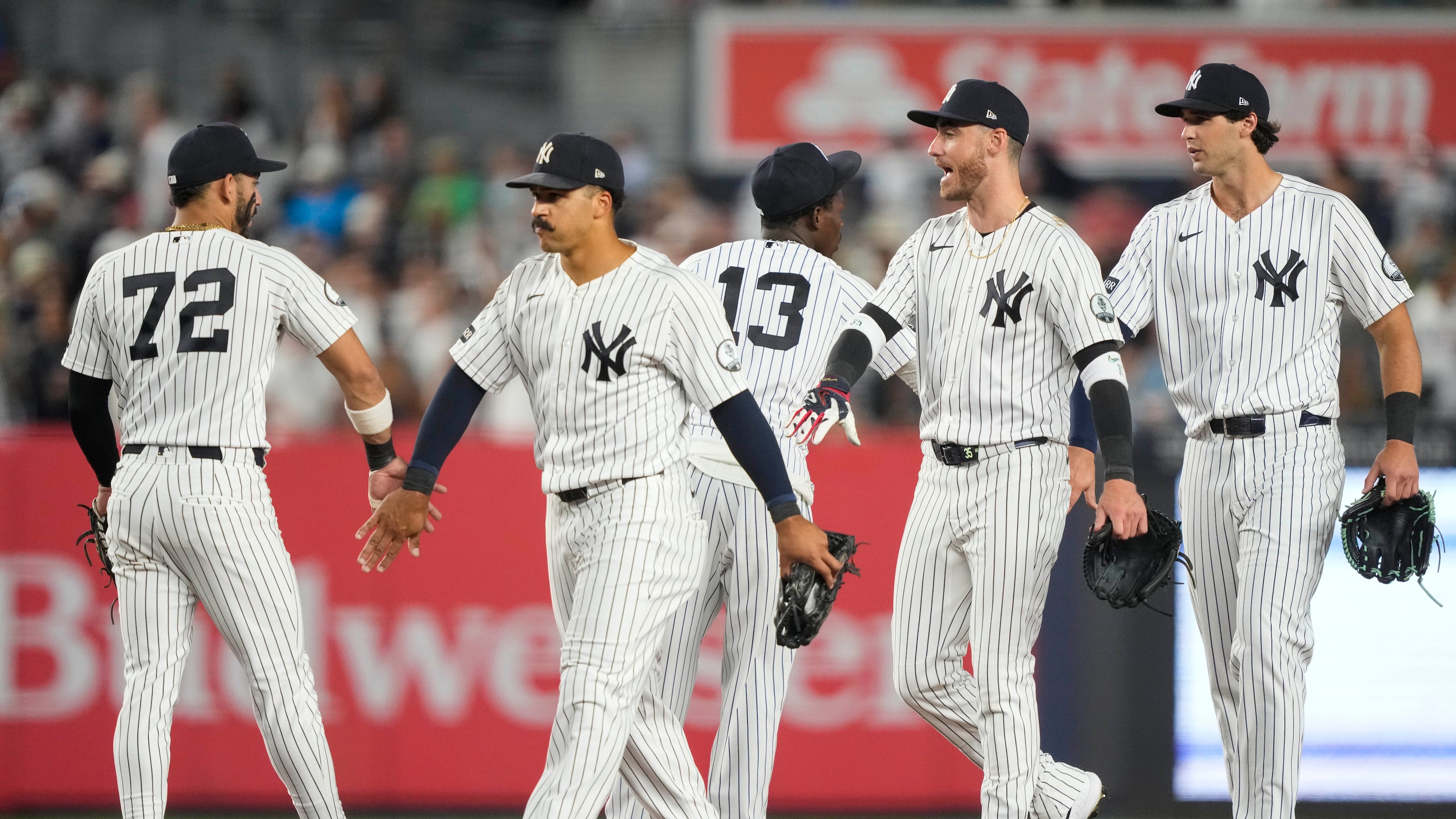 New York Yankees right fielder Spencer Jones, left fielder Cody Bellinger, and center fielder Trent Grisham, right to left, celebrate with teammates after winning a baseball game against the Boston Red Sox, Friday, Aug. 28, 2026, in New York. (AP Photo/Yuki Iwamura)