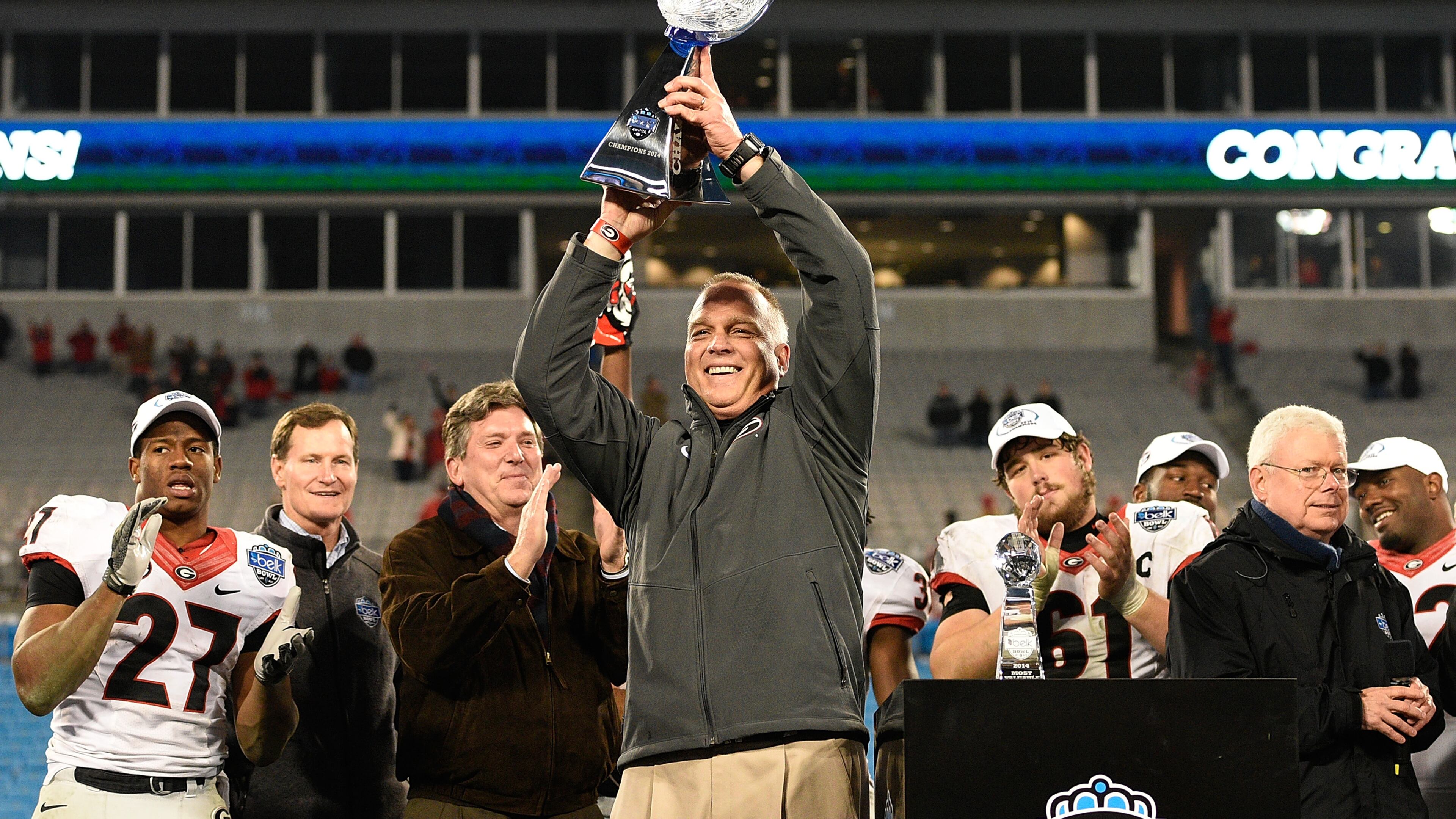 Head coach Mark Richt and the Georgia Bulldogs holds up the trophy after winning the Belk Bowl against the Louisville Cardinals at Bank of America Stadium on December 30, 2014 in Charlotte, North Carolina. Georgia won 37-14. (Photo by Grant Halverson/Getty Images)