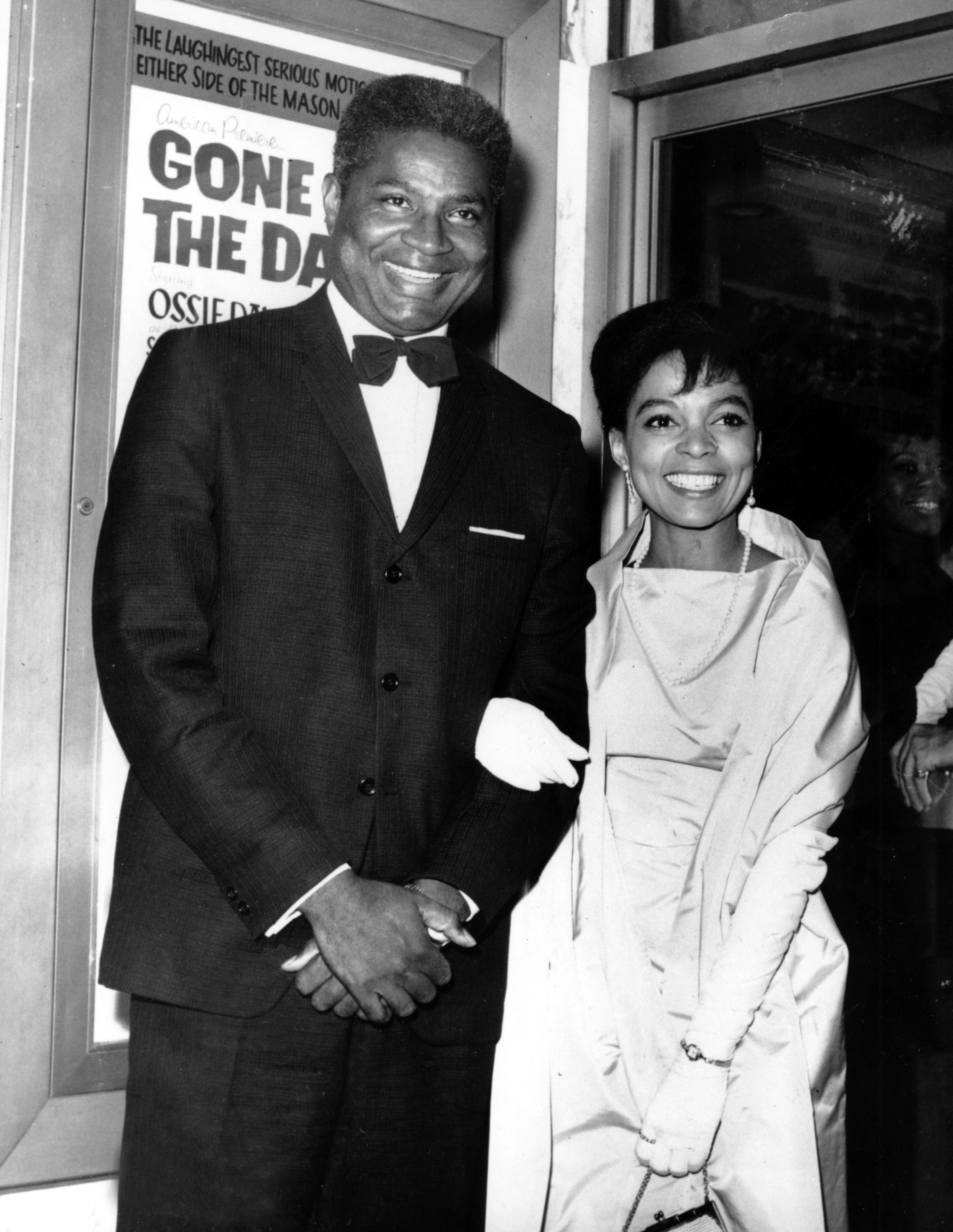 Ossie Davis and wife, Ruby Dee pose in front of their movie poster at the opening night gala of their film "Gone Are the Days!" in New York on Sept. 23, 1963. The movie, starring the married couple, was based on Davis's play "Purlie Victorious." (AP Photo)