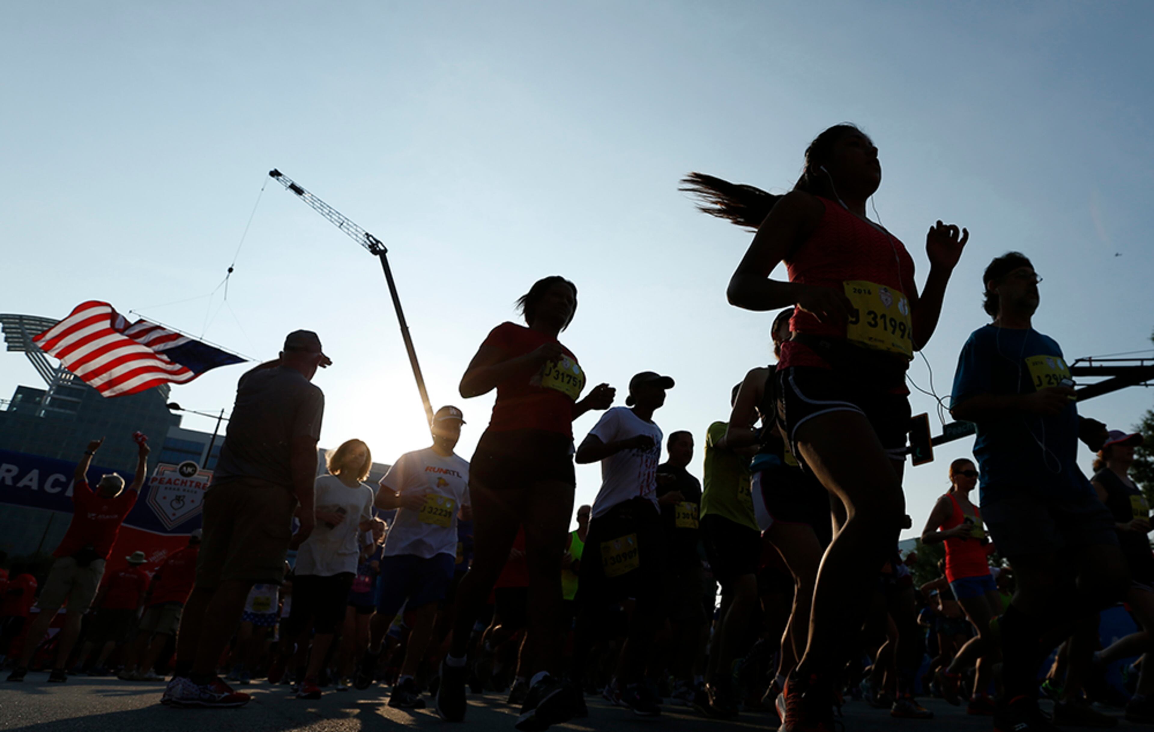 The U.S. flag flies over the starting line as racers begin the 47th running of the AJC Peachtree Road Race at Lenox Square Monday, July 4, 2016, in Atlanta.