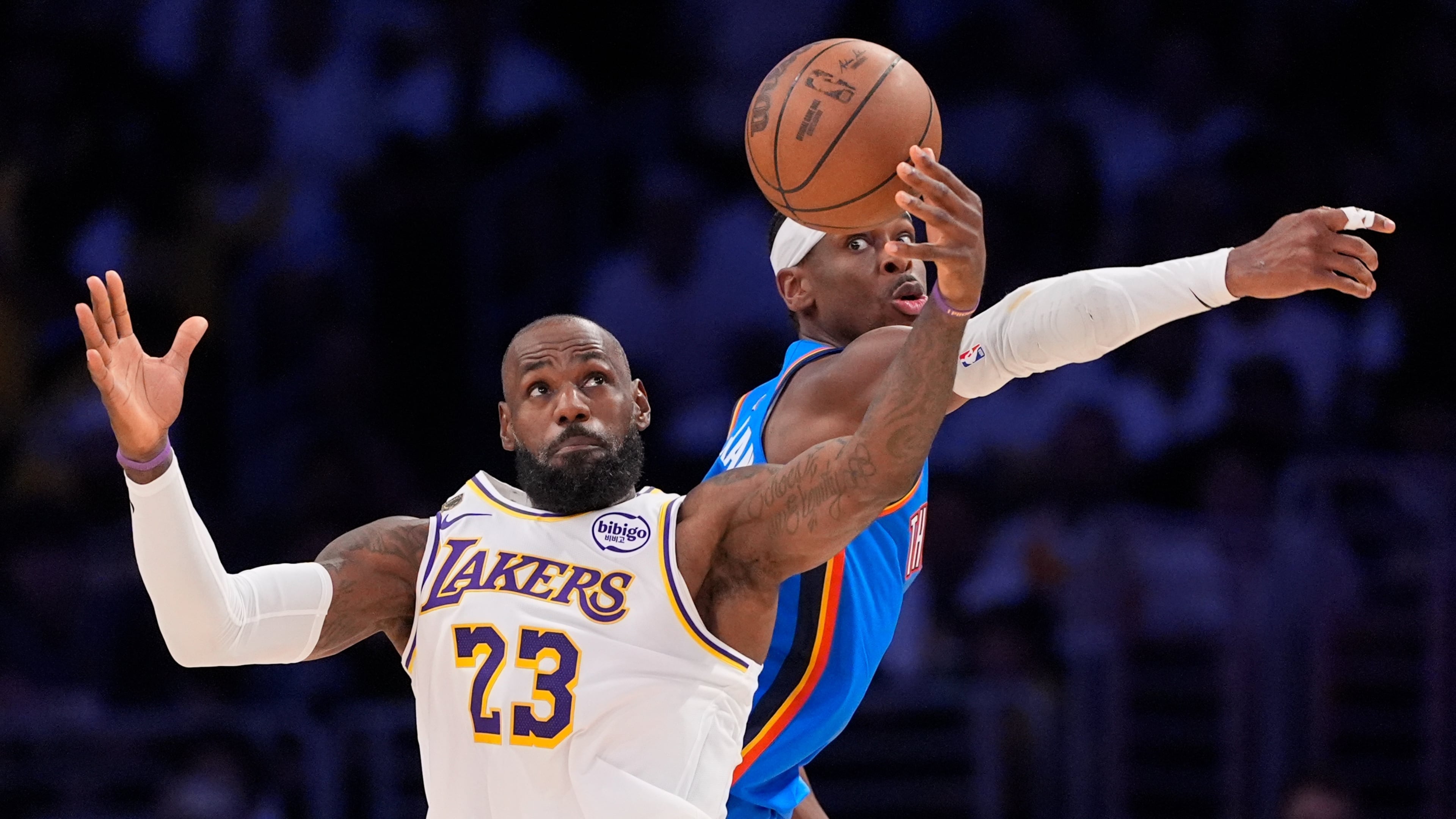 Los Angeles Lakers forward LeBron James, left, takes a pass as Oklahoma City Thunder guard Shai Gilgeous-Alexander defends during the first half of Game 3 in a second-round NBA basketball playoffs series Saturday, May 9, 2026, in Los Angeles. (AP Photo/Mark J. Terrill)