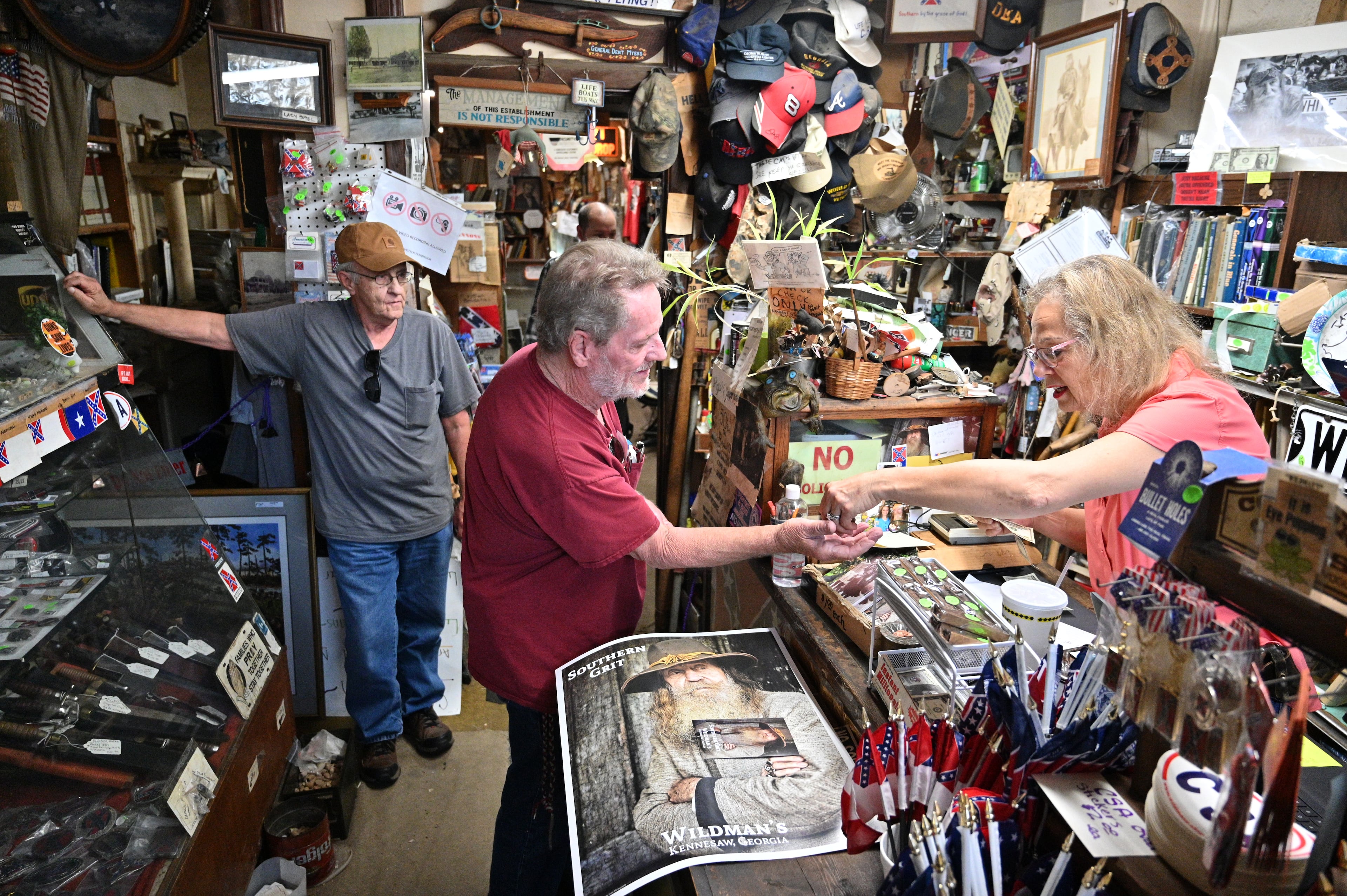 Longtime Wildman's employee Marjorie Lyon (right) — pictured helping a customer in the Kennesaw store in 2022 — recently provided a 2021 letter from late store owner Dent Myers in which he bequethed his stocks to Lyon. (Hyosub Shin/AJC 2022)
