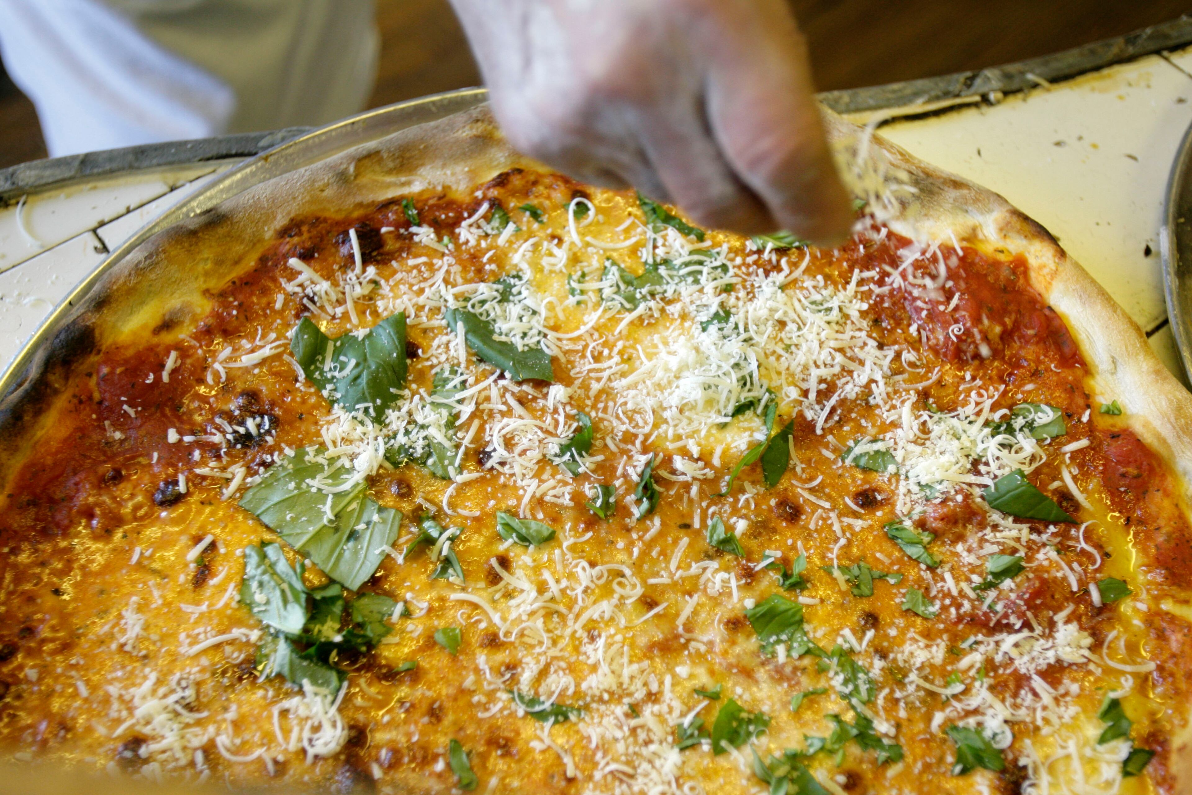 A trip to New York wouldn't be complete without a slice of pizza. Here, Dominico De Marco puts the finishing touches on a pie at his pizza restaurant, Di Fara Pizza, in New York on March 13, 2008.
