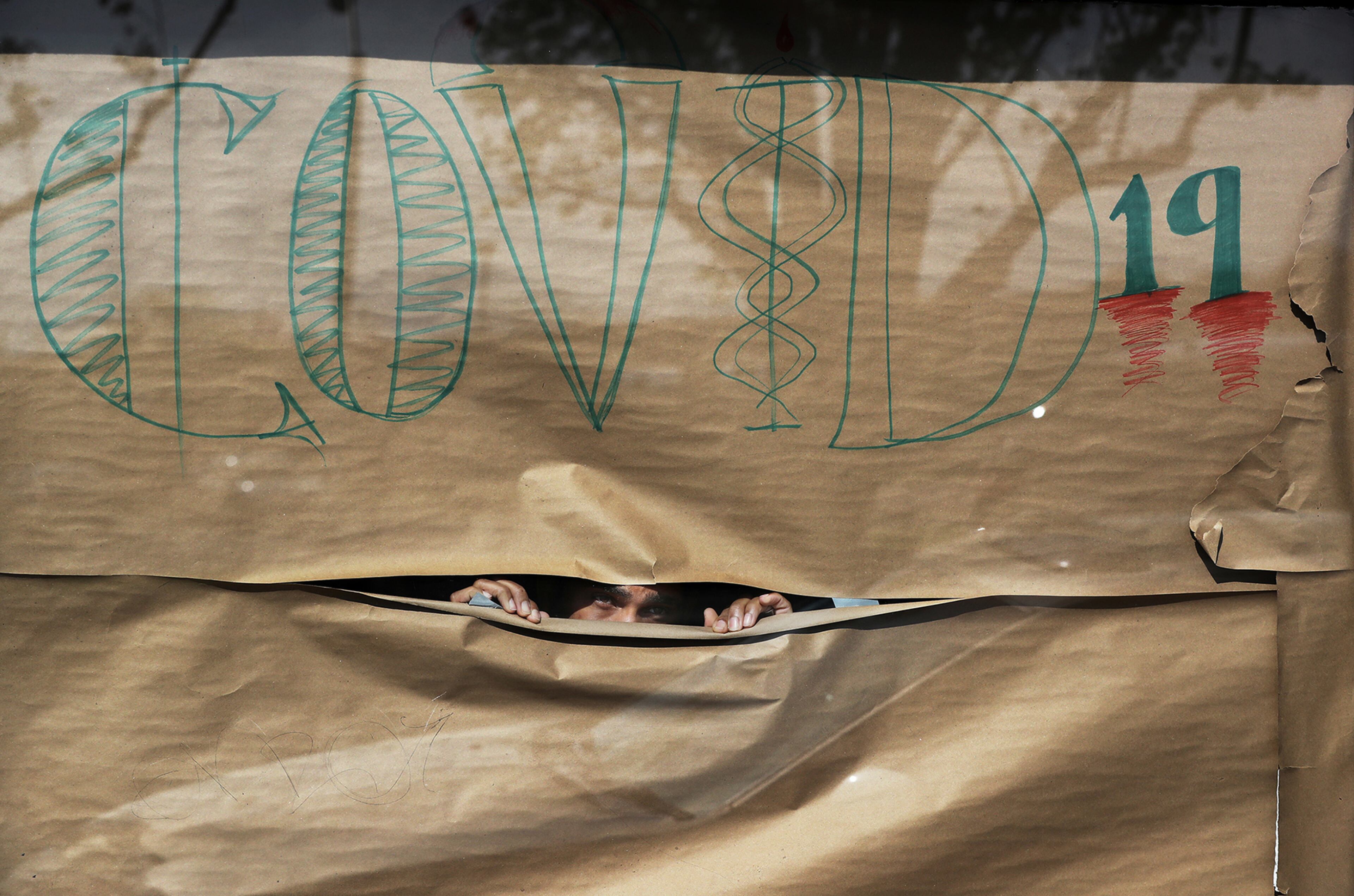 March 26, 2020 College Park: Frank Battle papers his windows to inform his customers he is closed for COVID-19 while closing up his barbershop business, The Shop on Mainstreet, on Thursday, March 26, 2020, in College Park. A patchwork of local officials, not the governor or president, this week ordered the closure of businesses across the state and forced people to shutter inside their homes over fears of COVID-19. Curtis Compton ccompton@ajc.com