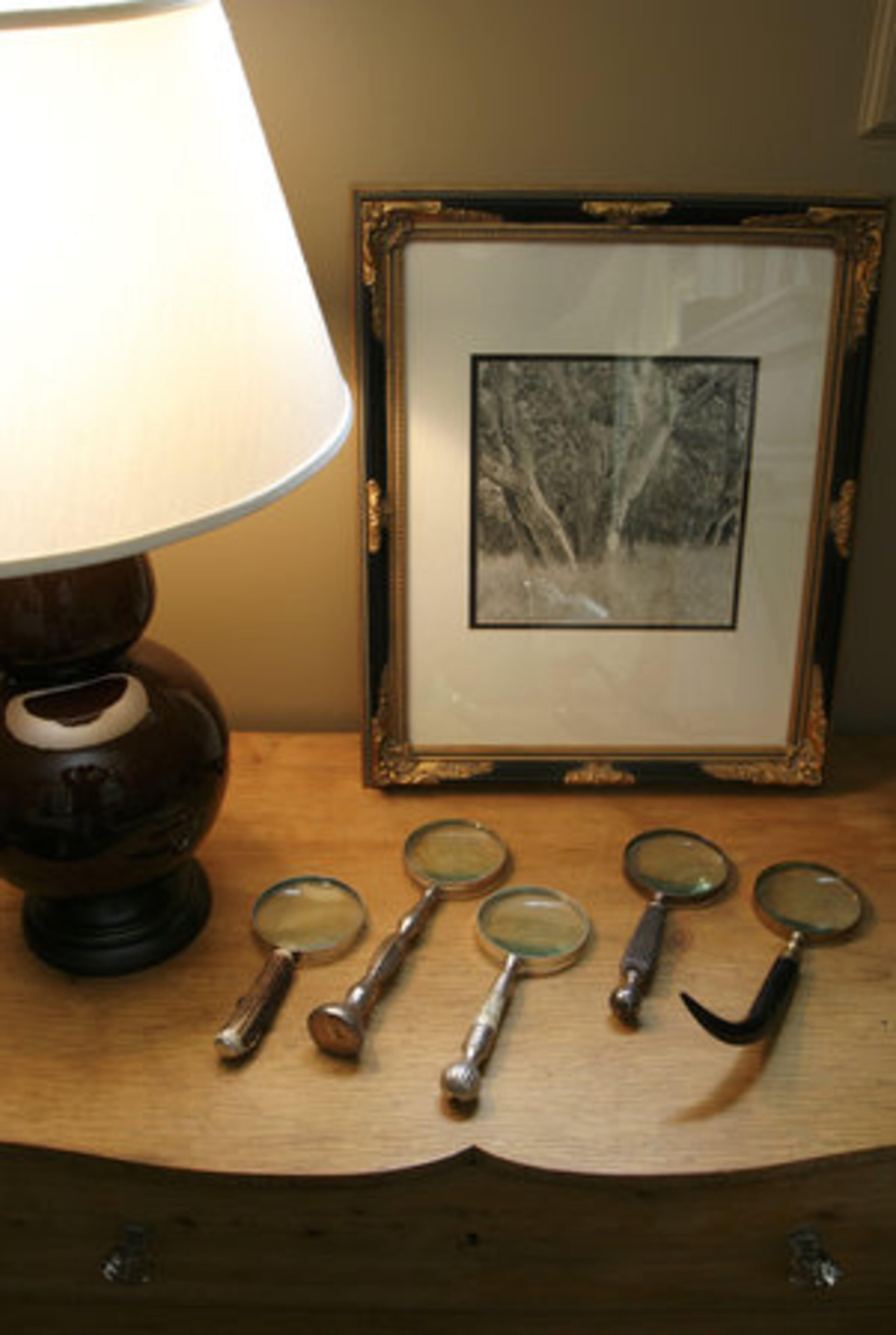A collection of magnifying lenses found at various garage sales rests on a night stand in the master suite.