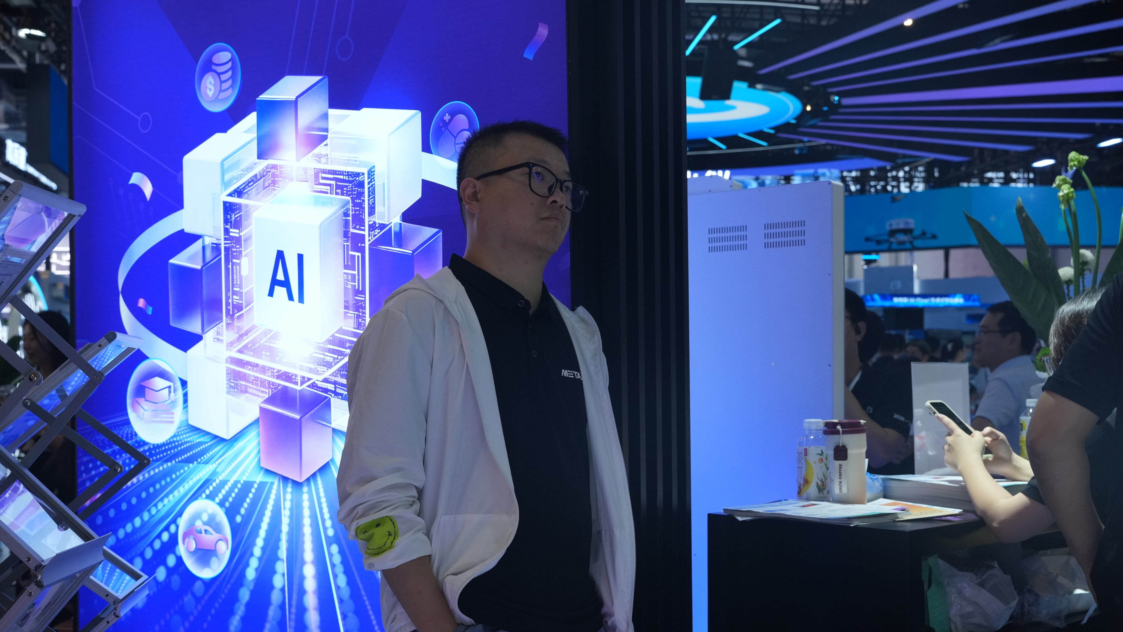 A visitor stands near a display about AI during the World AI Conference in Shanghai, China on July 17, 2026. (AP Photo/Ng Han Guan)