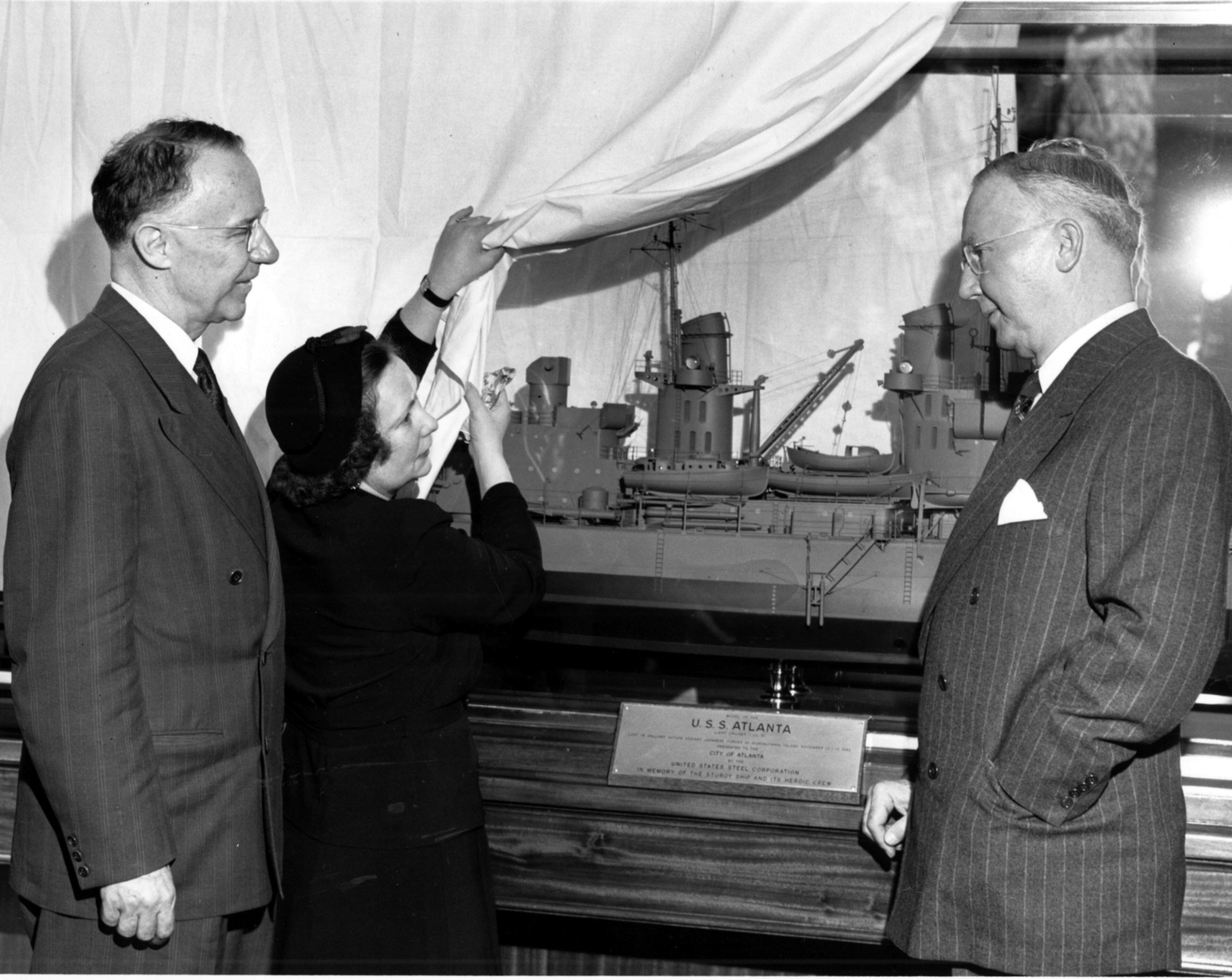 Jan. 1949 - "Gone With The Wind" author and Atlanta resident Margaret Mitchell admires a model of the ship USS Atlanta as Mayor William B. Hartsfield and Robert Gregg of U.S. Steel Corporation look on.
