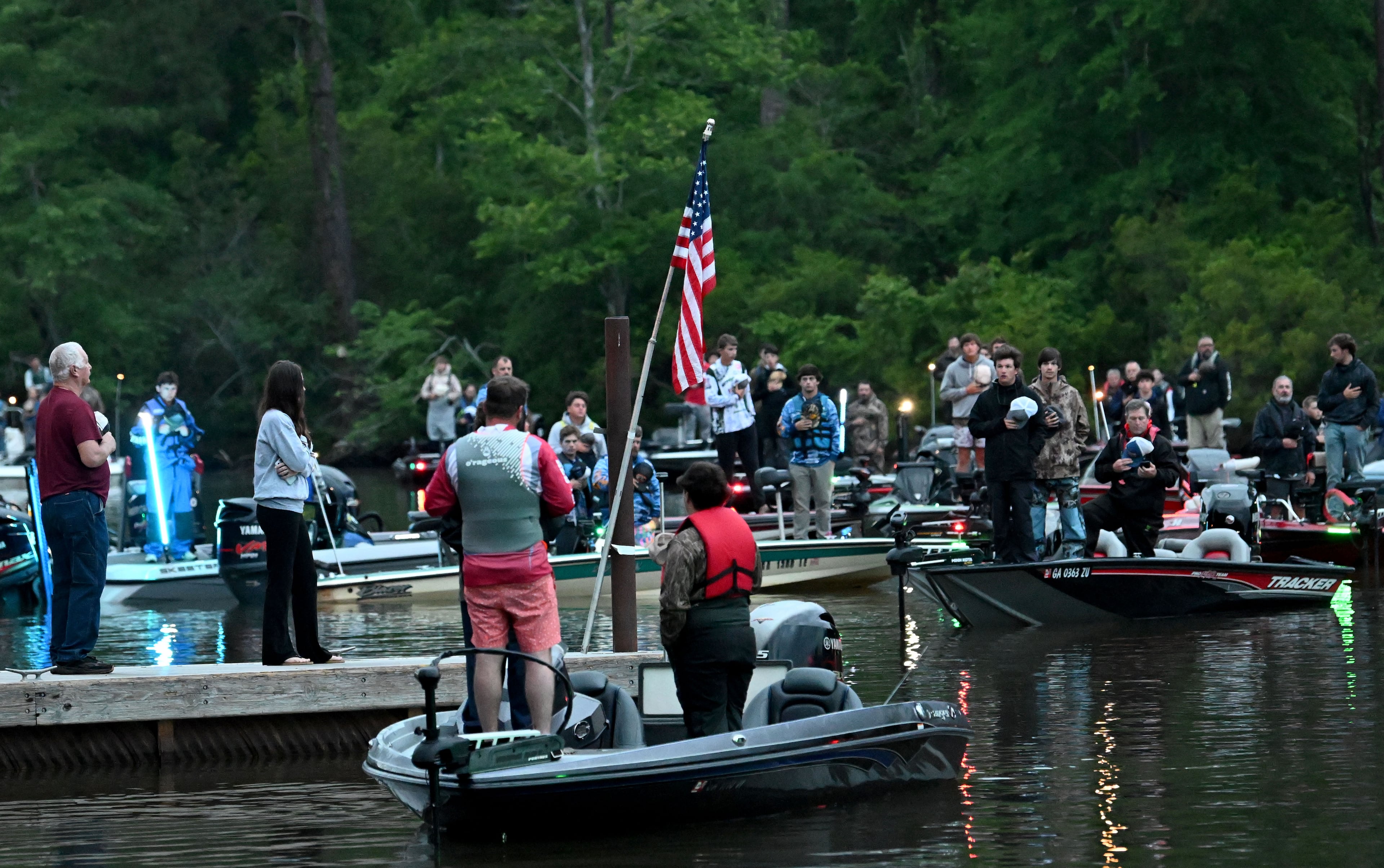 Contestants recite the Pledge of Allegiance from their boats before the start of the championship. (Hyosub Shin/AJC)