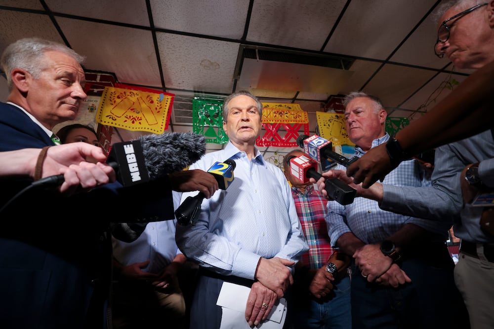 Republican nominee for governor Rick Jackson, center, speaks to reporters during a campaign event in Doraville in June. (Jason Getz/AJC)