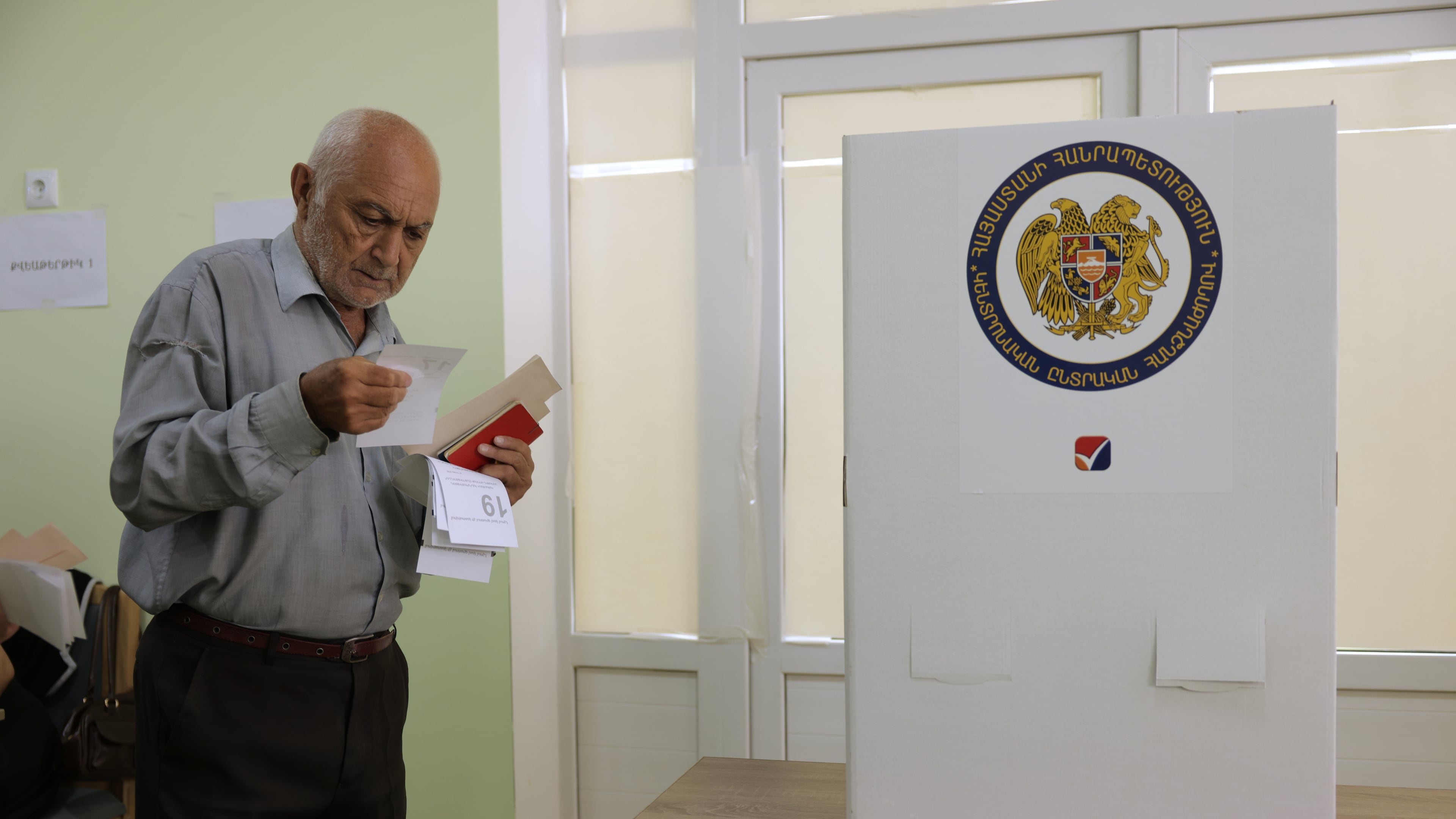 A man looks at his ballot at a polling station during the parliamentary election in Yerevan, Armenia, Sunday, June 7, 2026. (AP Photo/Anthony Pizzoferrato)