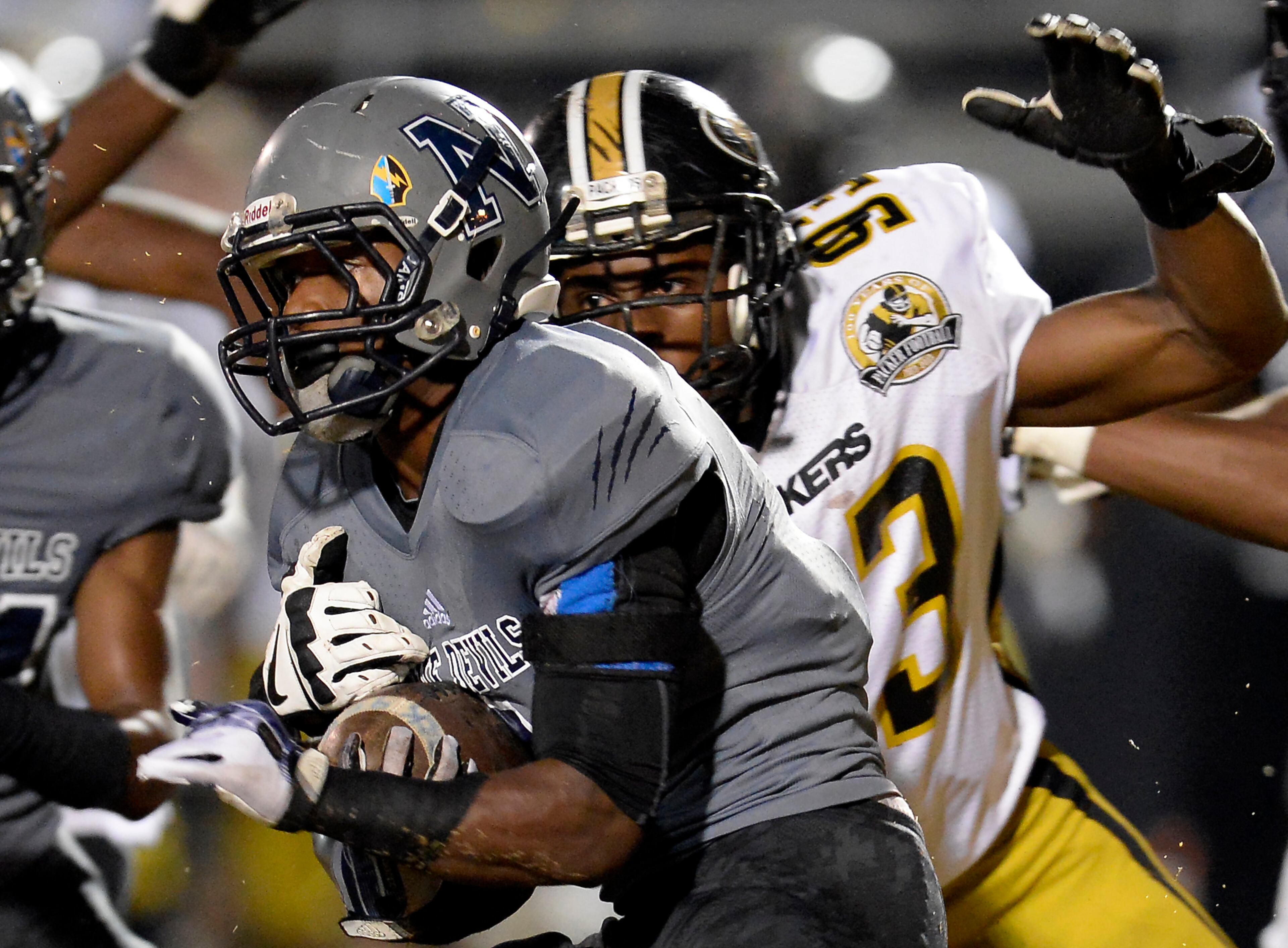 Norcross running back Josh Boyd, center, picks up short yardage in front of Colquitt County's Demetrius Walker (93) in the first half of their AAAAAA semifinal high school football game at Blue Devil Stadium on Friday, Dec. 6, 2013, in Norcross, Ga.