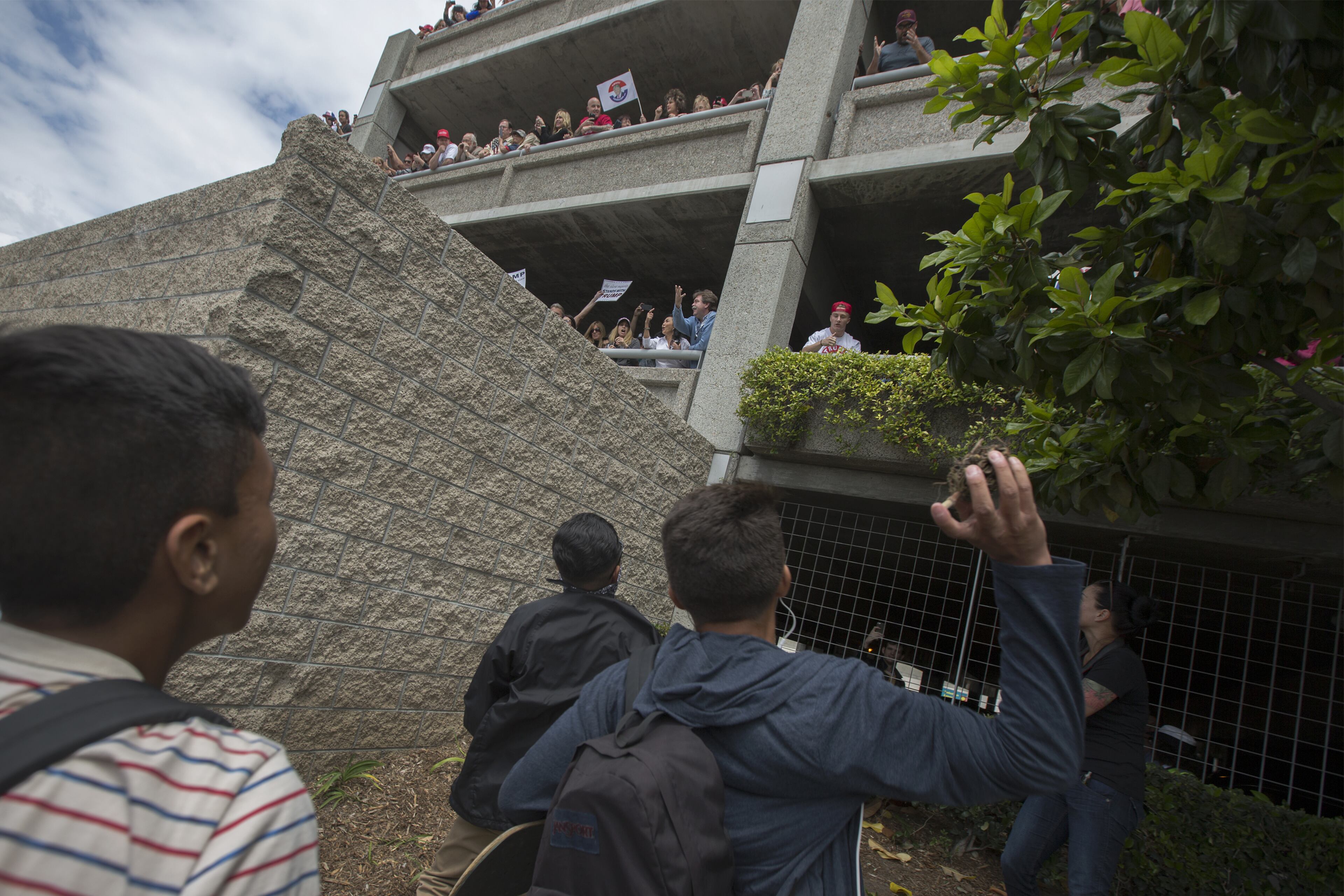 ANAHEIM, CA - MAY 25: A protester throws a piece of a plant as Trump supporters in a parking structure and protesters passing below hurl insults and debris at one another near a campaign rally by presumptive GOP presidential candidate Donald Trump at the Anaheim Convention Center on May 25, 2016 in Anaheim, California. Previous visits by the candidate to Orange County have sparked in protests that resulted in some arrests. The presidential candidates are campaigning in Southern California for the June 7 California primary. (Photo by David McNew/Getty Images)