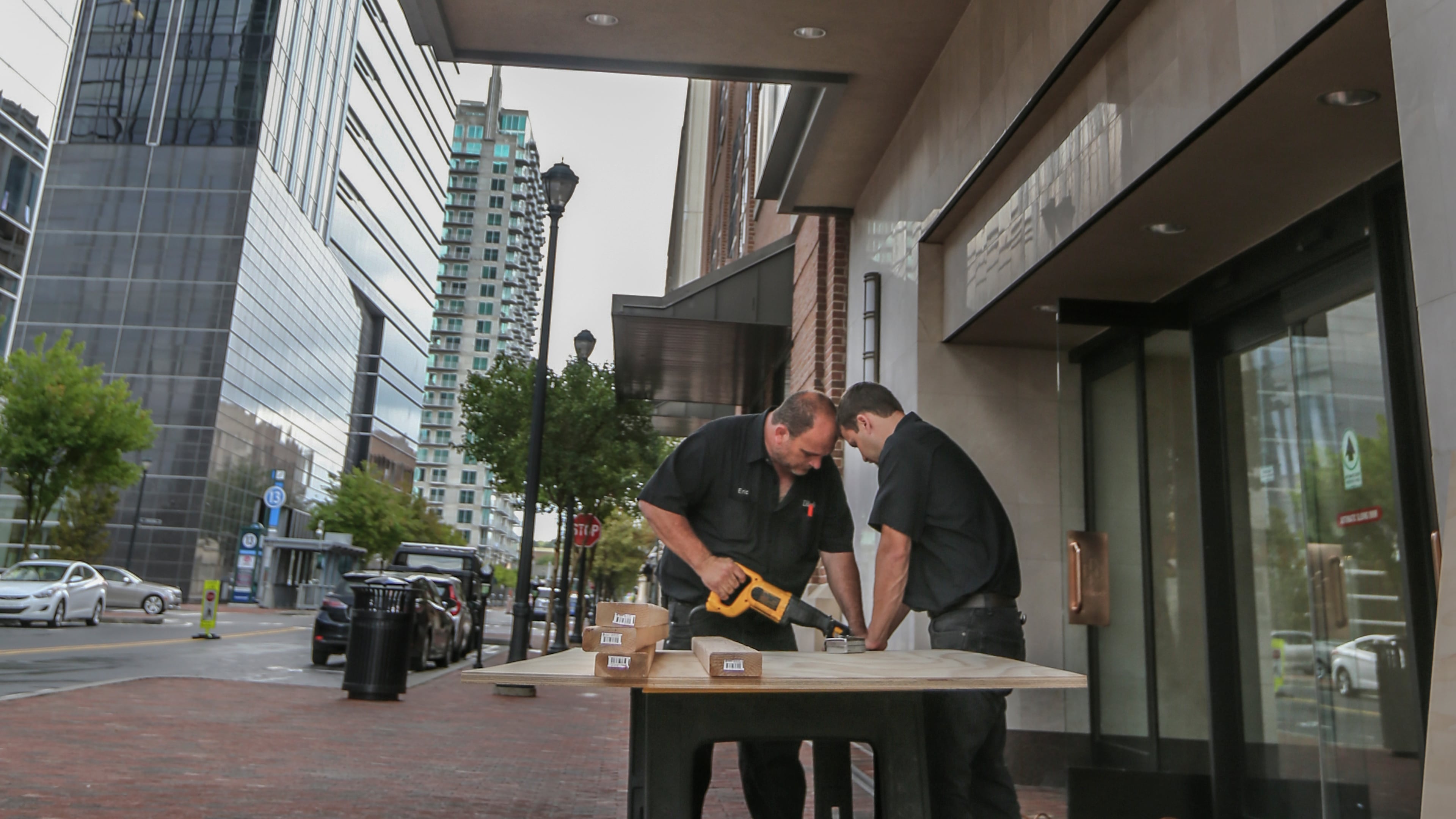 Workers begin to repair damage Tuesday after burglars smashed into the Dillard’s department store at Atlantic Station early Tuesday, making off with nearly $35,000 in high-dollar jeans and hoodies. JOHN SPINK / JSPINK@AJC.COM