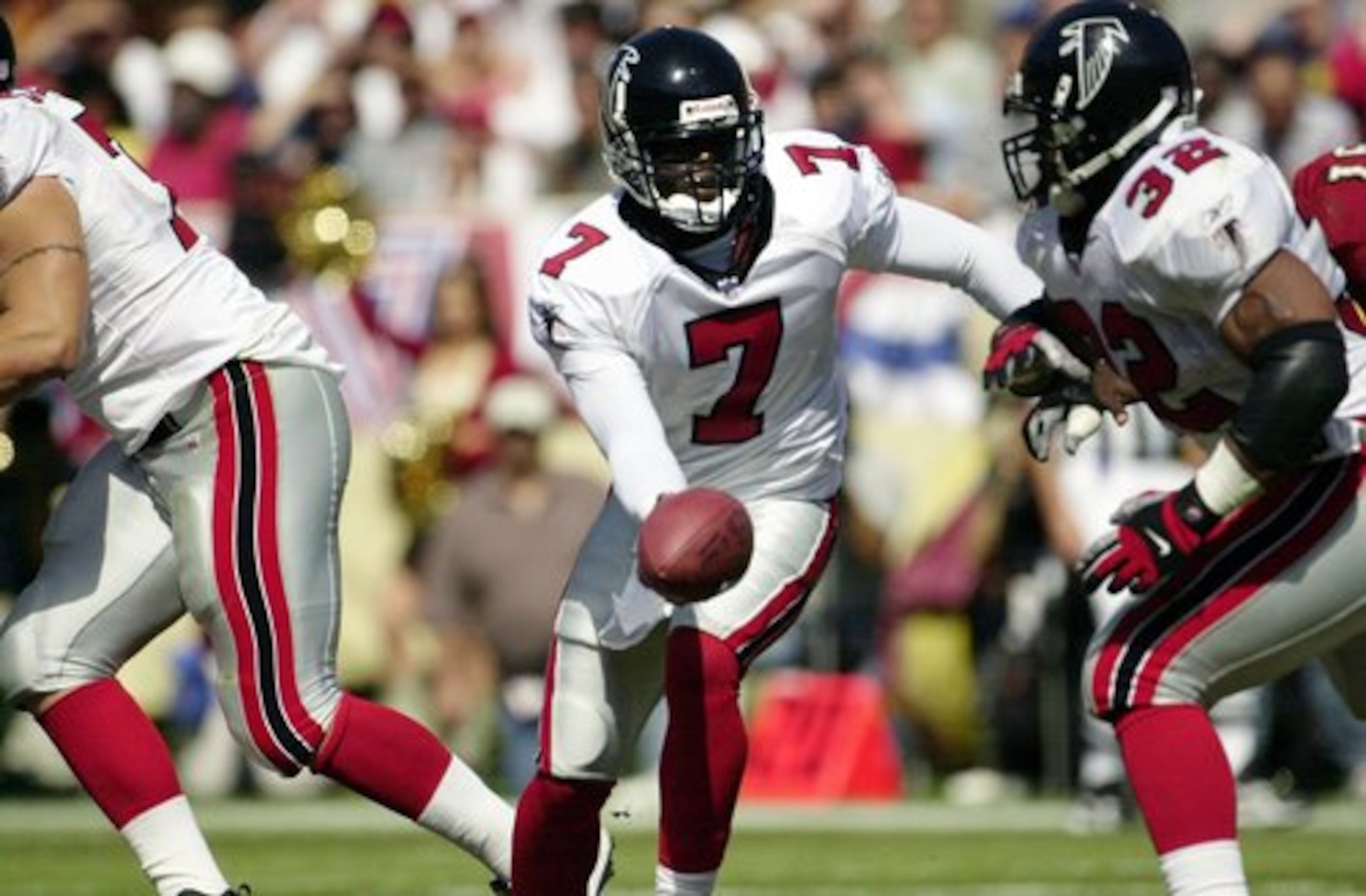 Sept. 9, 2001 -- Vick hands off the ball to former Falcon Jamal Anderson in Vick's first National Football League game. The Falcons alternated Vick and starting quarterback Chris Chandler throughout the game. The Falcons lost in overtime 16-13.