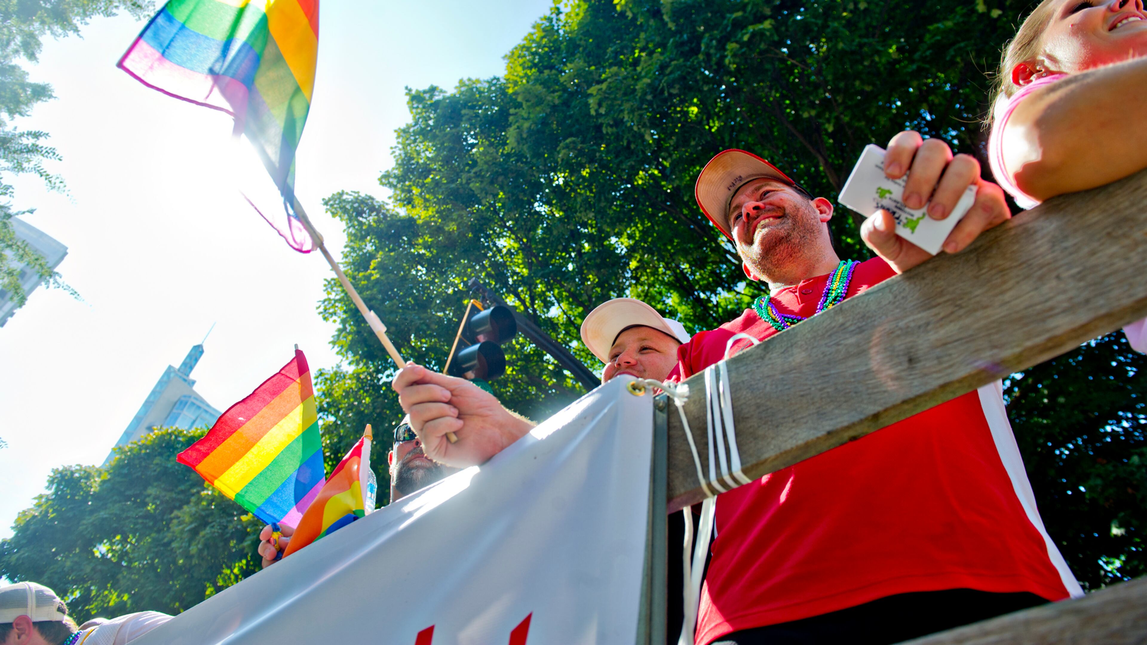 Ricky Howell (center) waves a rainbow flag as he rides a float down Peachtree Street during the Atlanta Pride Parade on Sunday, October 12, 2014. JONATHAN PHILLIPS / SPECIAL