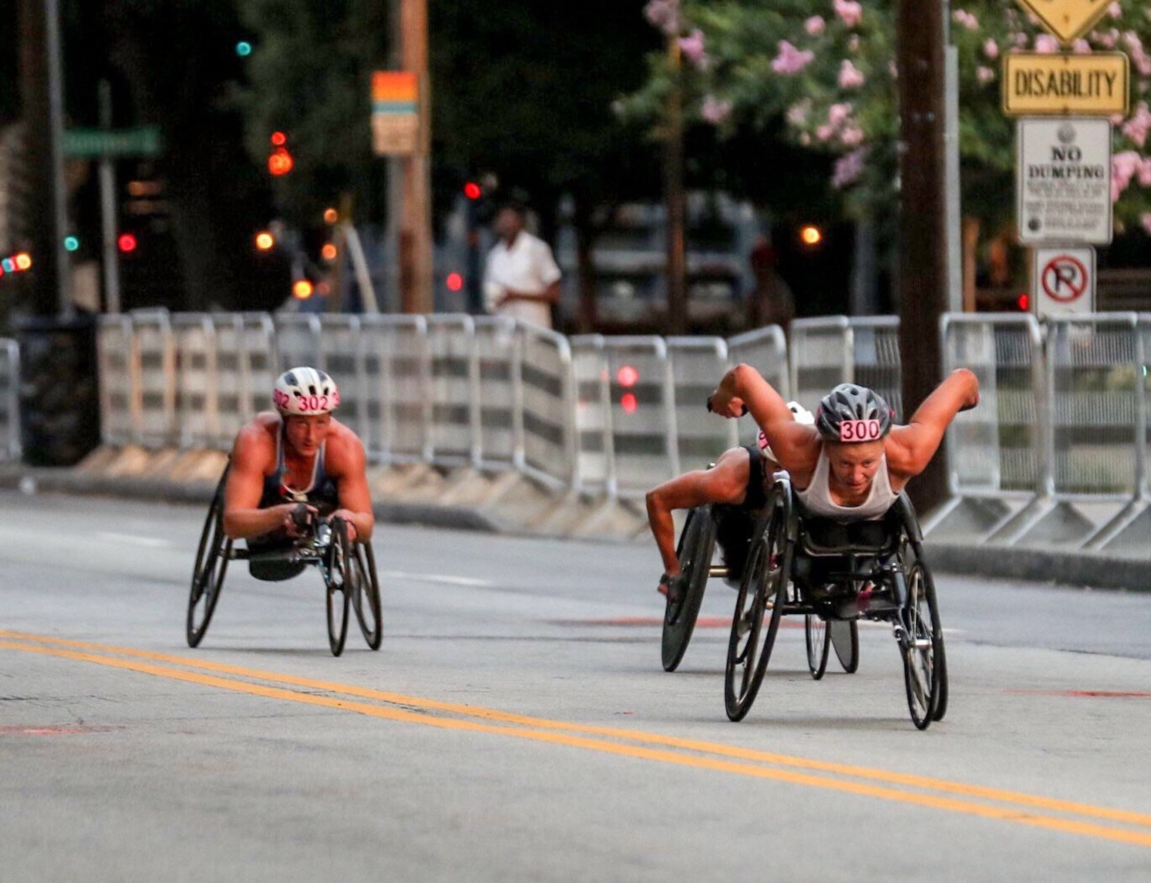 Wheelchair race participants approach 10th Street NE and Piedmont Avenue NE during the AJC Peachtree Road Race in Atlanta, Thursday, July 4, 2019. (Alyssa Pointer/alyssa.pointer@ajc.com)