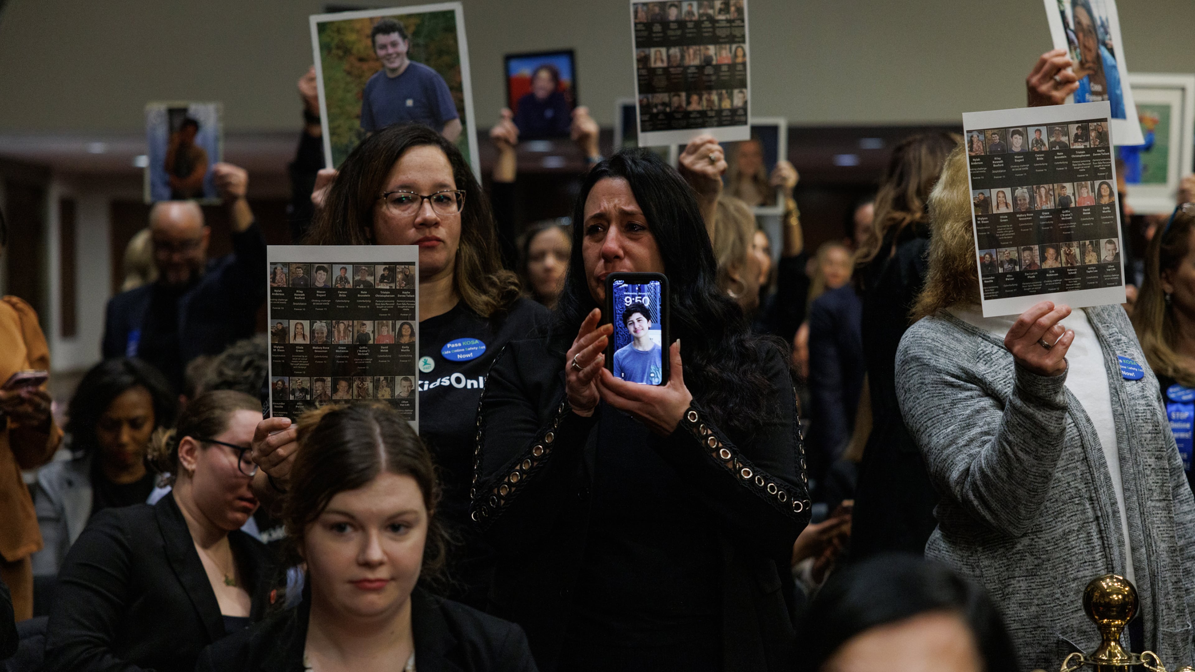 The families of children who were victims of online exploitation and abuse hold up pictures at a U.S. Senate Judiciary Committee hearing, where the chief executives of Meta, Snap, Discord, X and TikTok testified in 2024. (Anna Rose Layden/The New York Times)