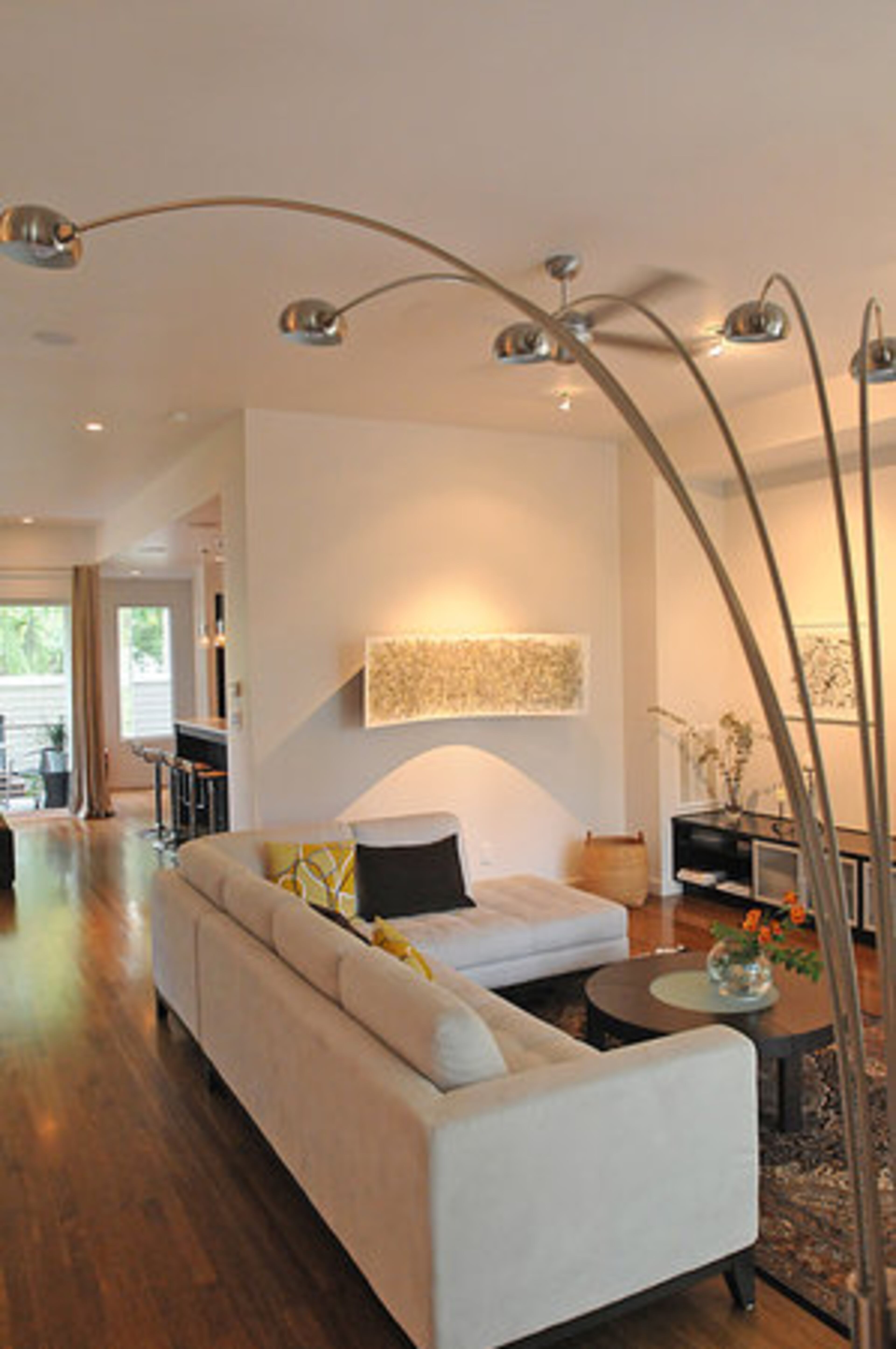 This modern and efficient light structure is one of the highlights of the living room area. The three-dimensional art piece basked in soft light along one wall is also a focal point of the room.