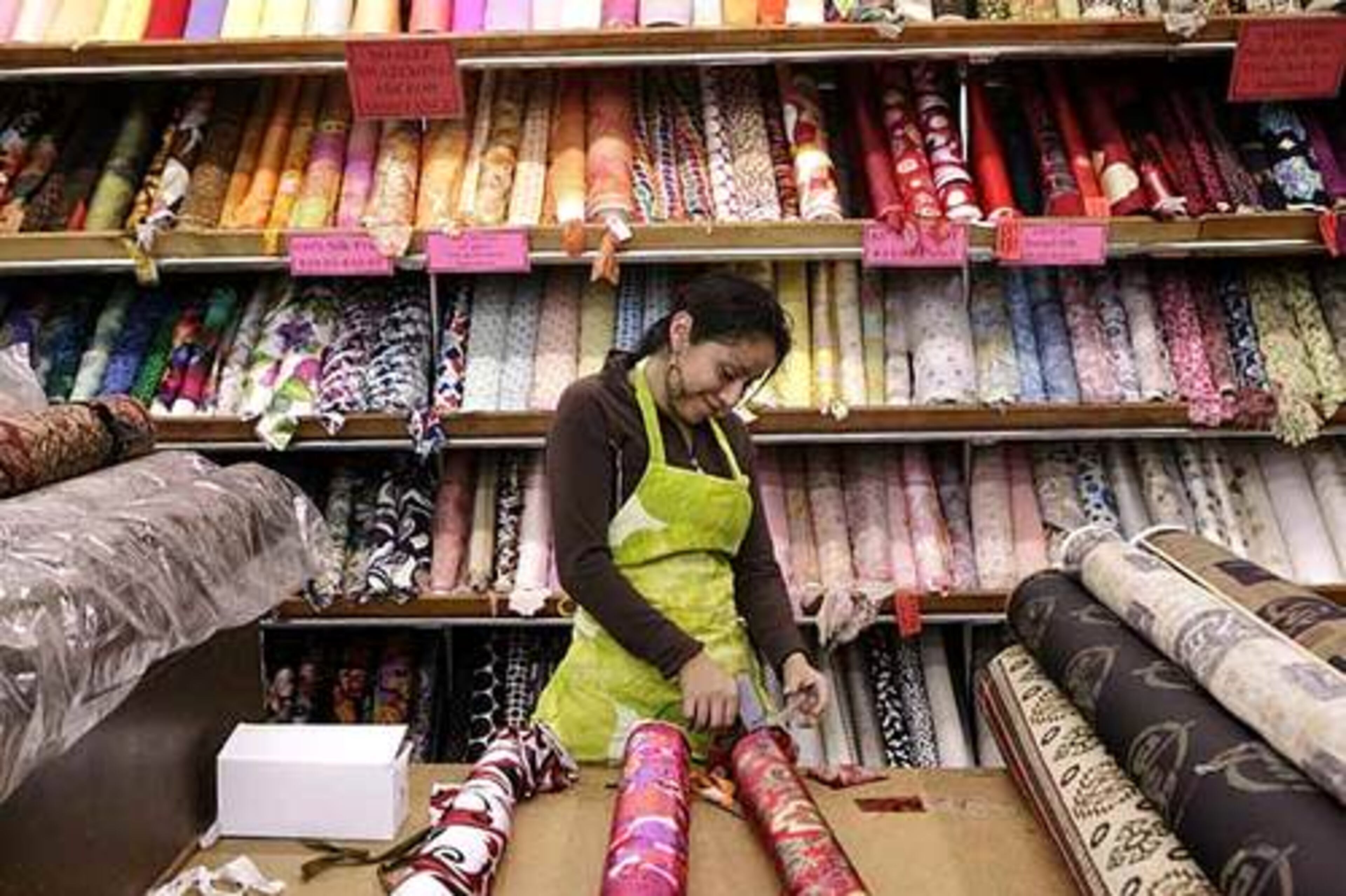 A woman organizes fabric roles at Elegant Fabrics in New York's Garment District.