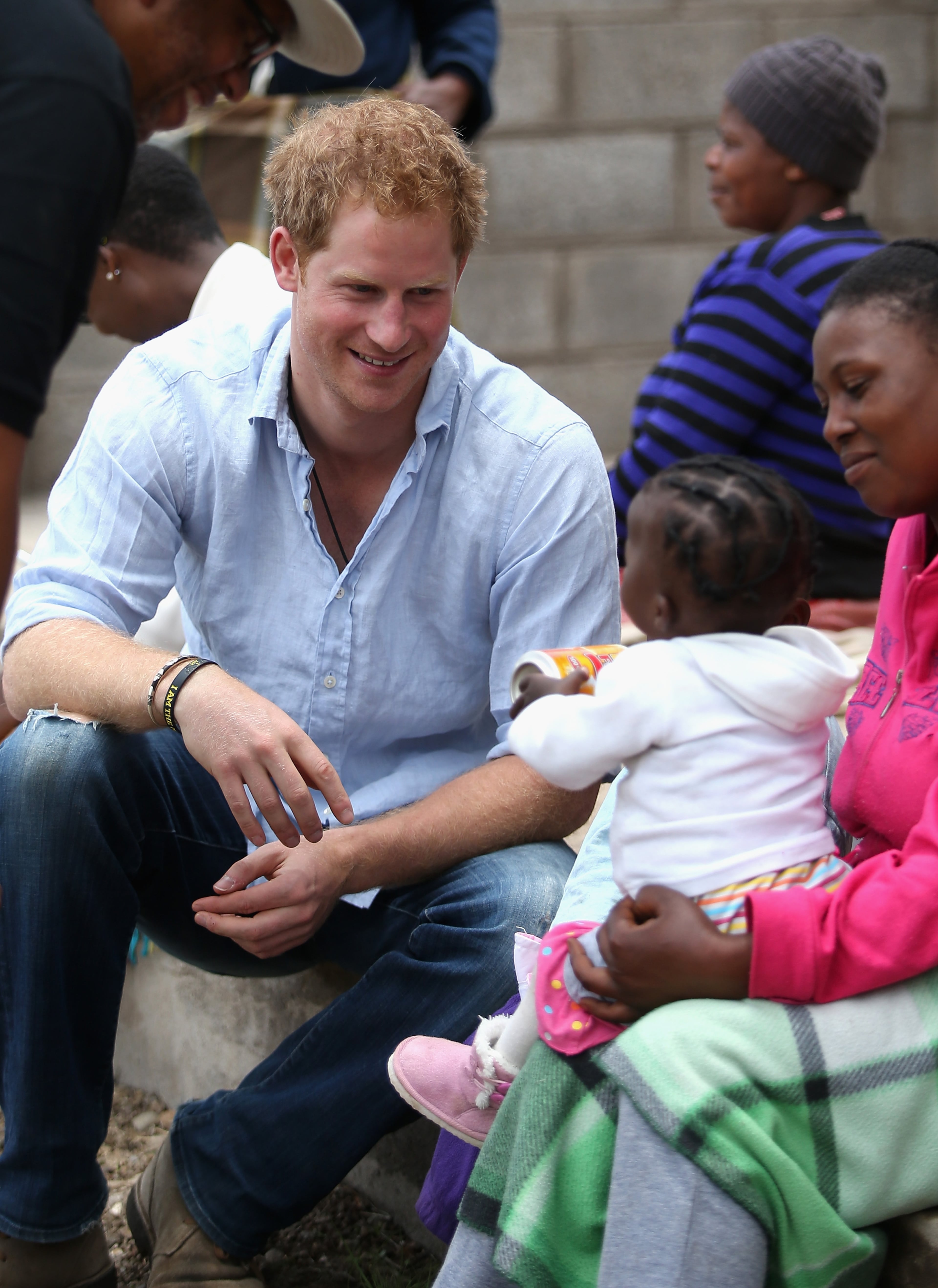 Prince Harry meets a baby during a visit to a herd boy night school constructed by Sentebale on December 8, 2014 in Mokhotlong, Lesotho. Prince Harry was visiting Lesotho to see the work of his charity Sentebale. Sentebale provides healthcare and education to vulnerable children in Lesotho, Southern Africa. The particular theme of his visit was to check on the progress of the Mamohato Childrens Centre which will provide vital support to children affected by HIV. Prince Harry founded Sentebale (which means Forget Me Not in Sesotho) with Prince Seeiso in 2006. (Photo by Chris Jackson/Getty Images for Sentebale)