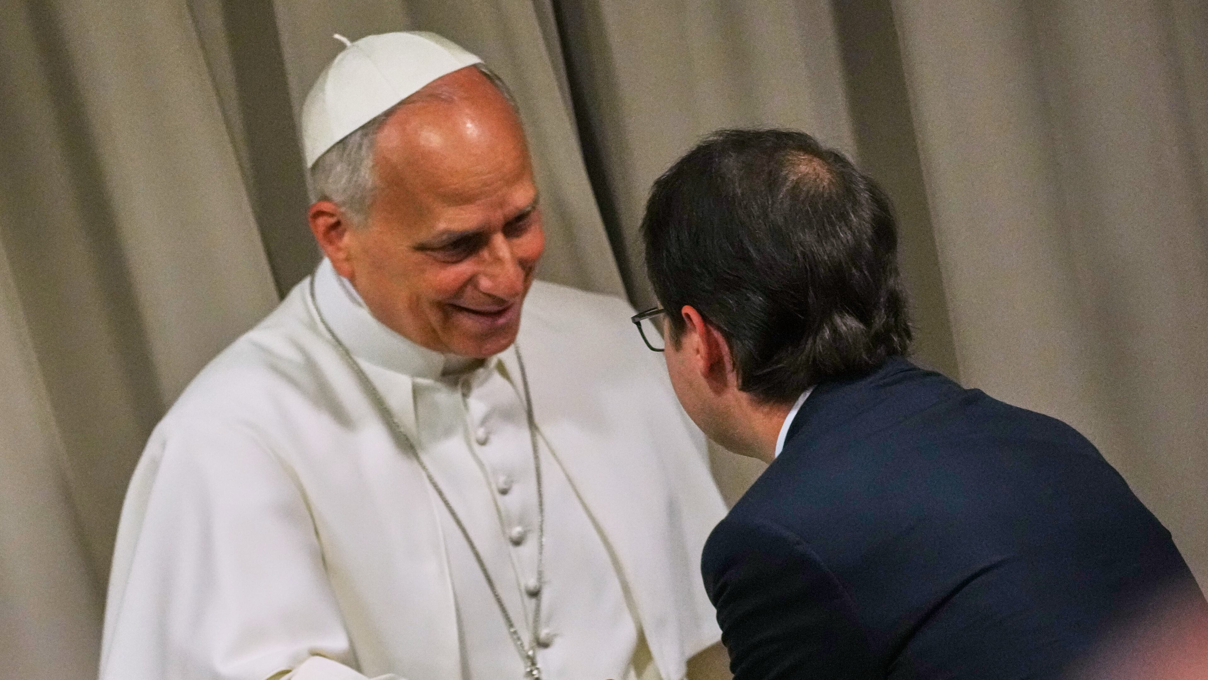 Pope Leo XIV, left, greets Anthropic co-founder Christopher Olah during the presentation of the Pope's first encyclical, "Magnifica humanitas: On Safeguarding the Human Person in the Time of Artificial Intelligence," at the Vatican, Monday, May 25, 2026. (AP Photo/Alessandra Tarantino)