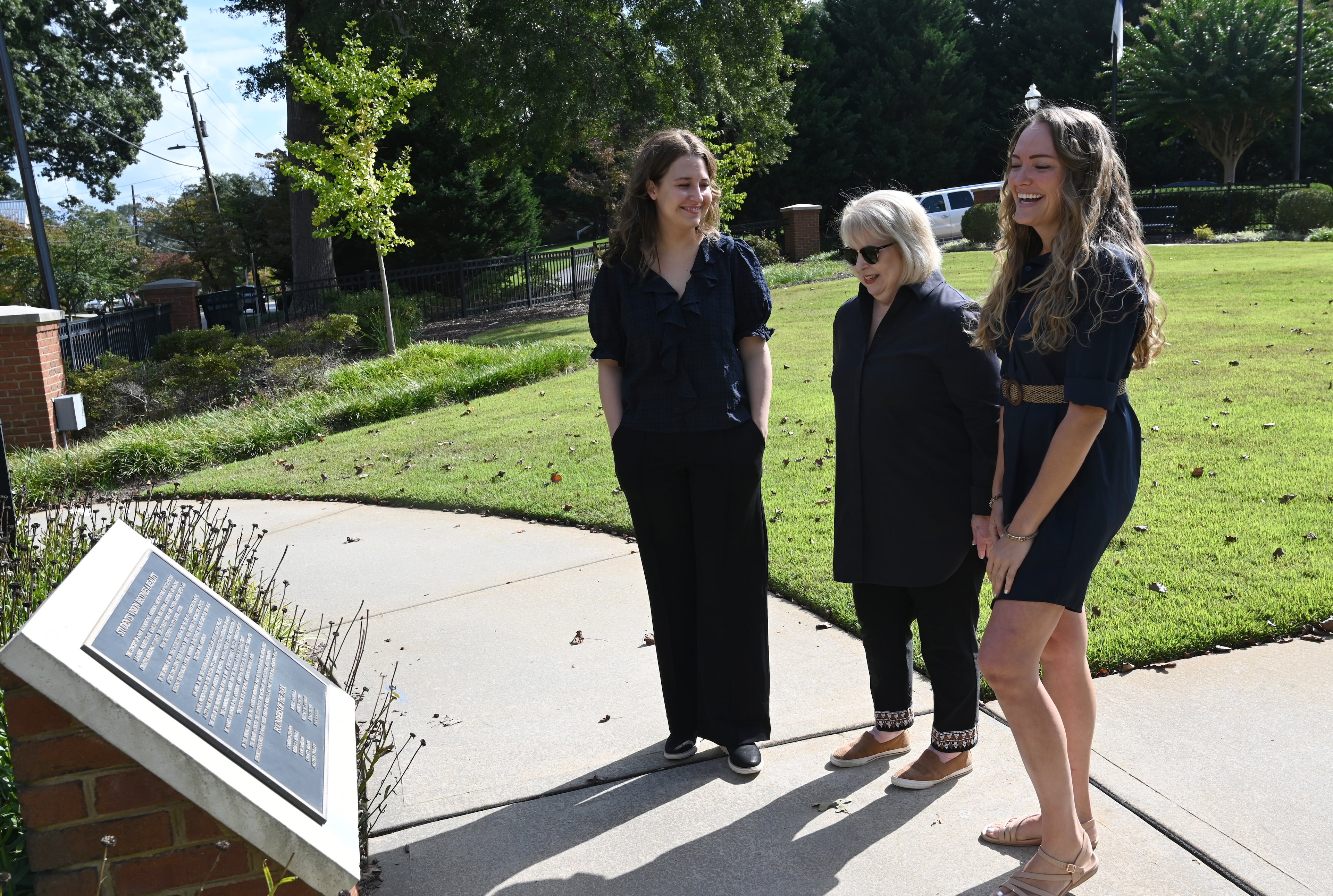Cynthia Sanders (center), 4th grade gifted class teacher of 1998-99, talks with her former students Rebecca Watson (left) and Allyson Twilley as they look at the founders’ plaque at Paul Anderson Memorial Park in Toccoa. The park resulted from a class project. (Hyosub Shin/AJC)