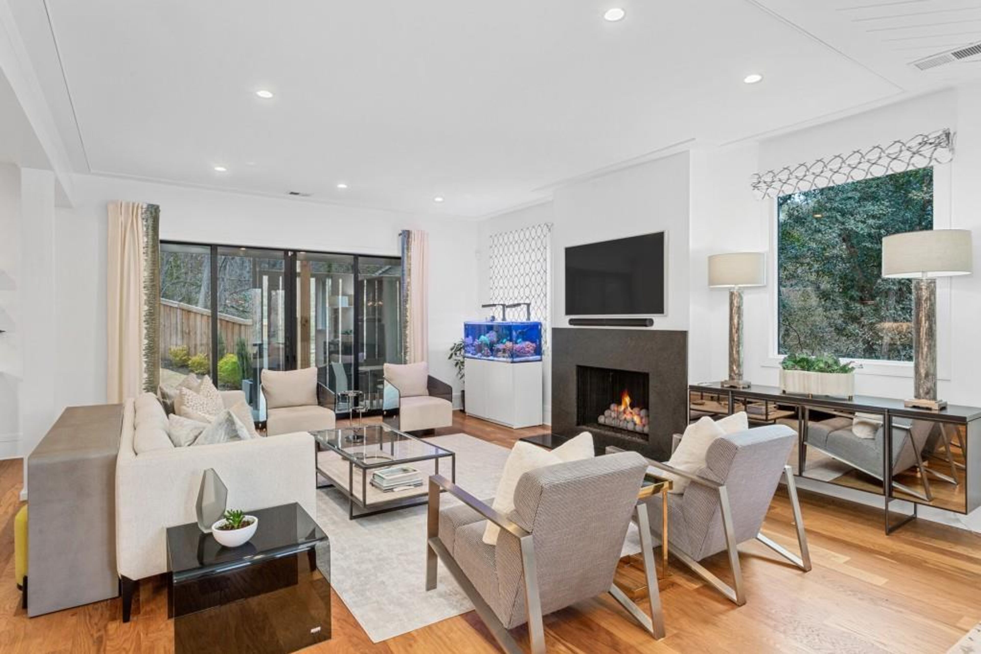 Kitchen opens to fireside great room featuring oversized glass nano doors that create a seamless transition into covered outdoor living space.