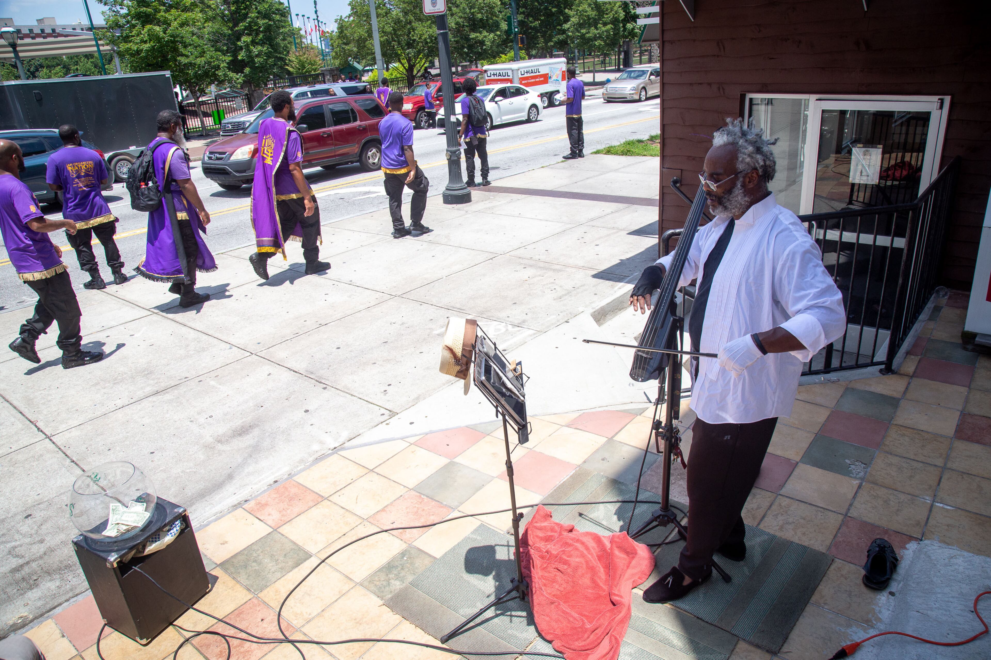 Jehovah Michael Paul plays his electric bass, as people walk by near the CNN center Saturday, June 20, 2020. STEVE SCHAEFER FOR THE ATLANTA JOURNAL-CONSTITUTION