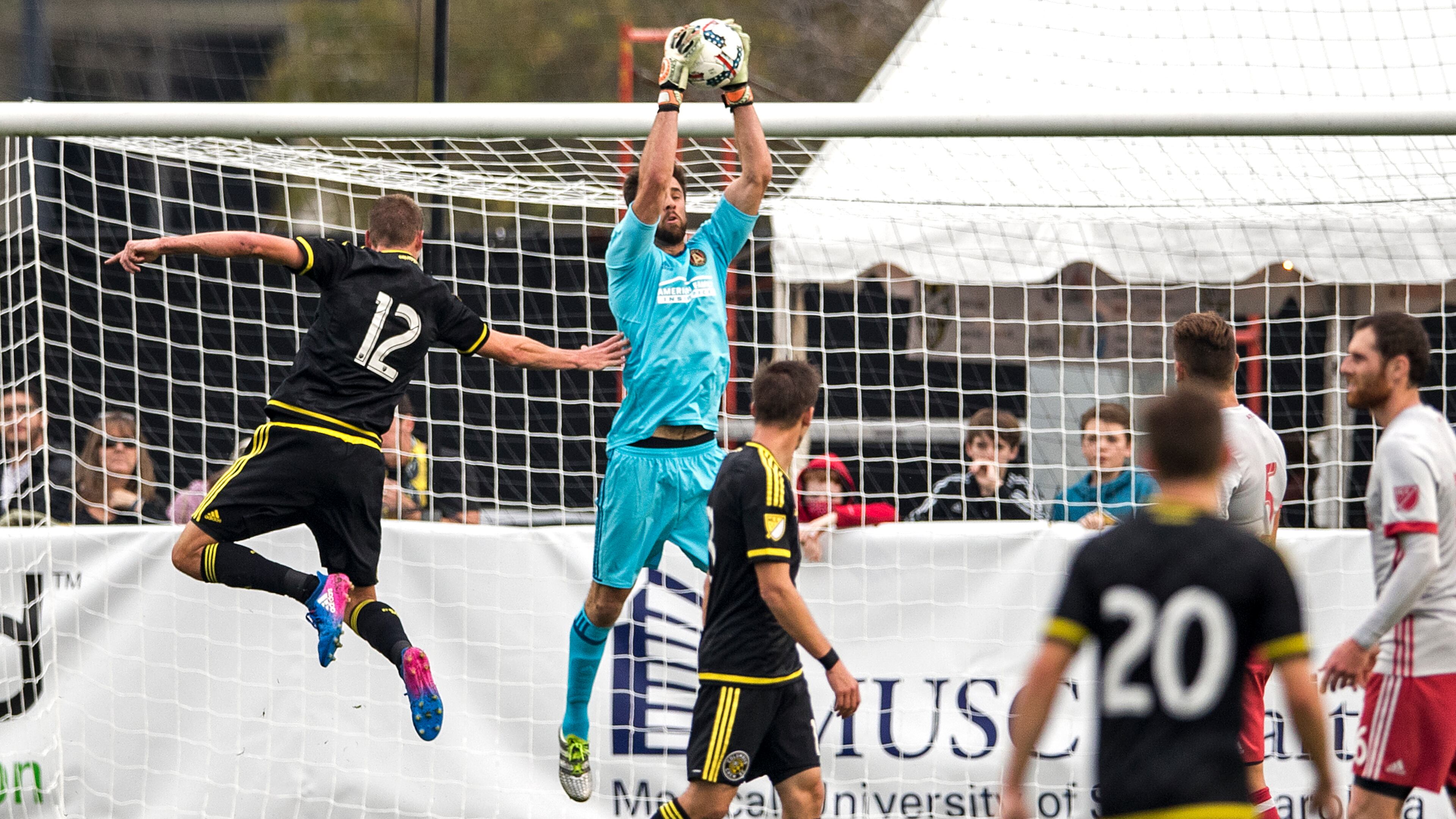 Charleston, South Carolina - February 18, 2017: Atlanta United goalie Alec Kann grabs the ball out of the air and keeps Crew forward Adam Jahn (#12) from connecting with it on Saturday, Feb. 18, 2017 in Charleston. (Photo by Alex Holt)