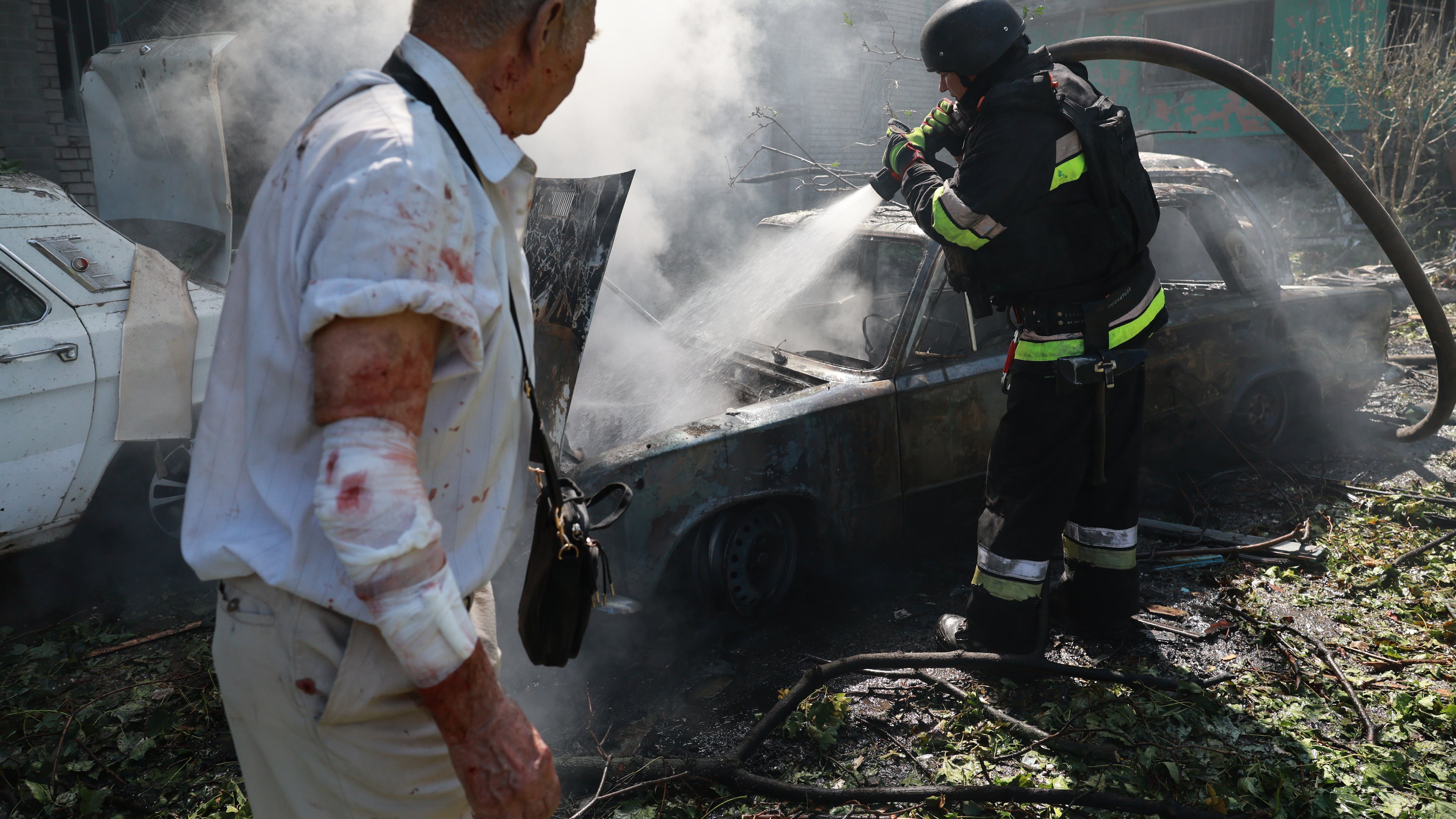 Rescue workers try to put out a fire of a residential building and cars burning after a Russian air guided bomb strike in Zaporizhzhia, Ukraine, Monday, Aug. 10, 2026. (AP Photo/Kateryna Klochko)