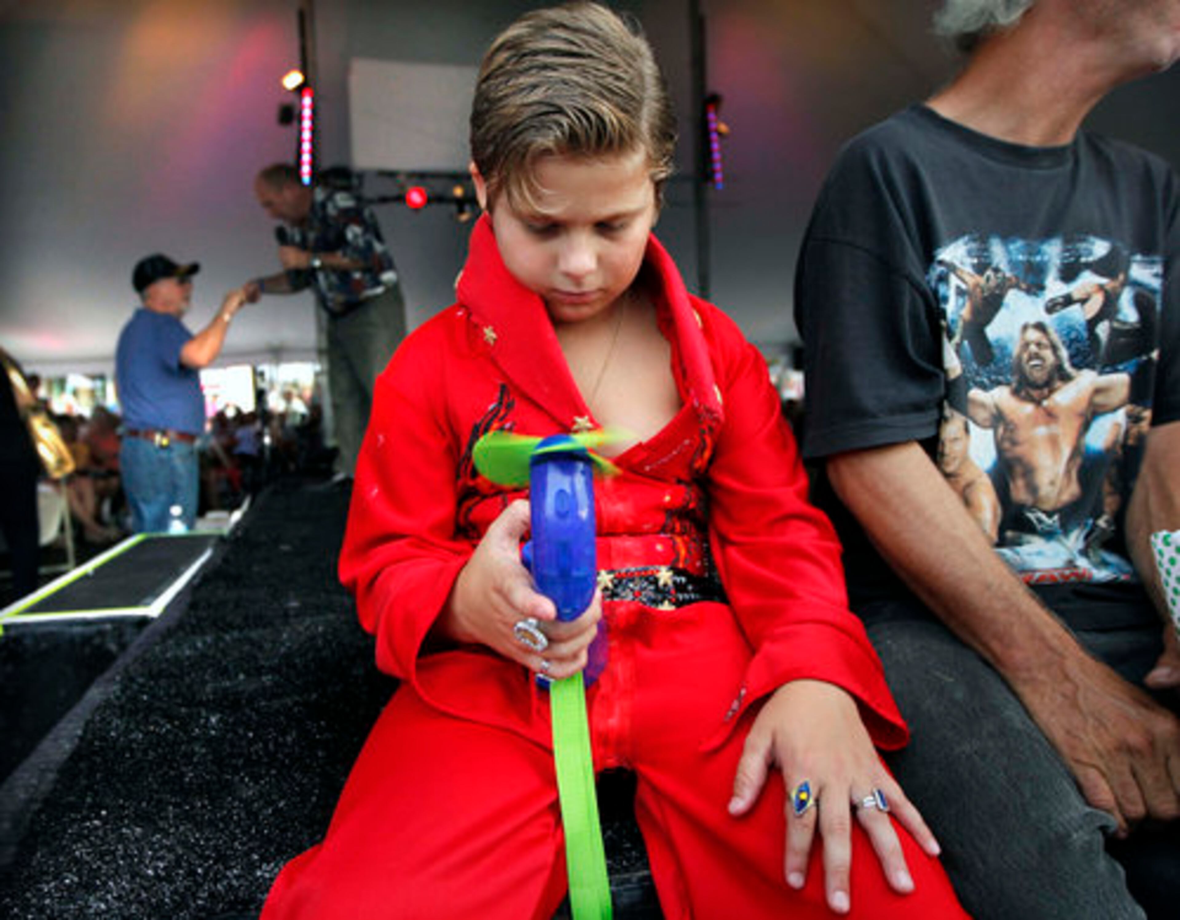 THE KING REMEMBERED--Brandon Bird, 9, tries to keep cool in his self-designed jumpsuit during a series of performances by Elvis tribute artists at the Graceland Entertainment Pavilion in Memphis, Tenn., before a vigil marking the 34th anniversary of the death of Elvis Presley Monday night, Aug. 15, 2011.