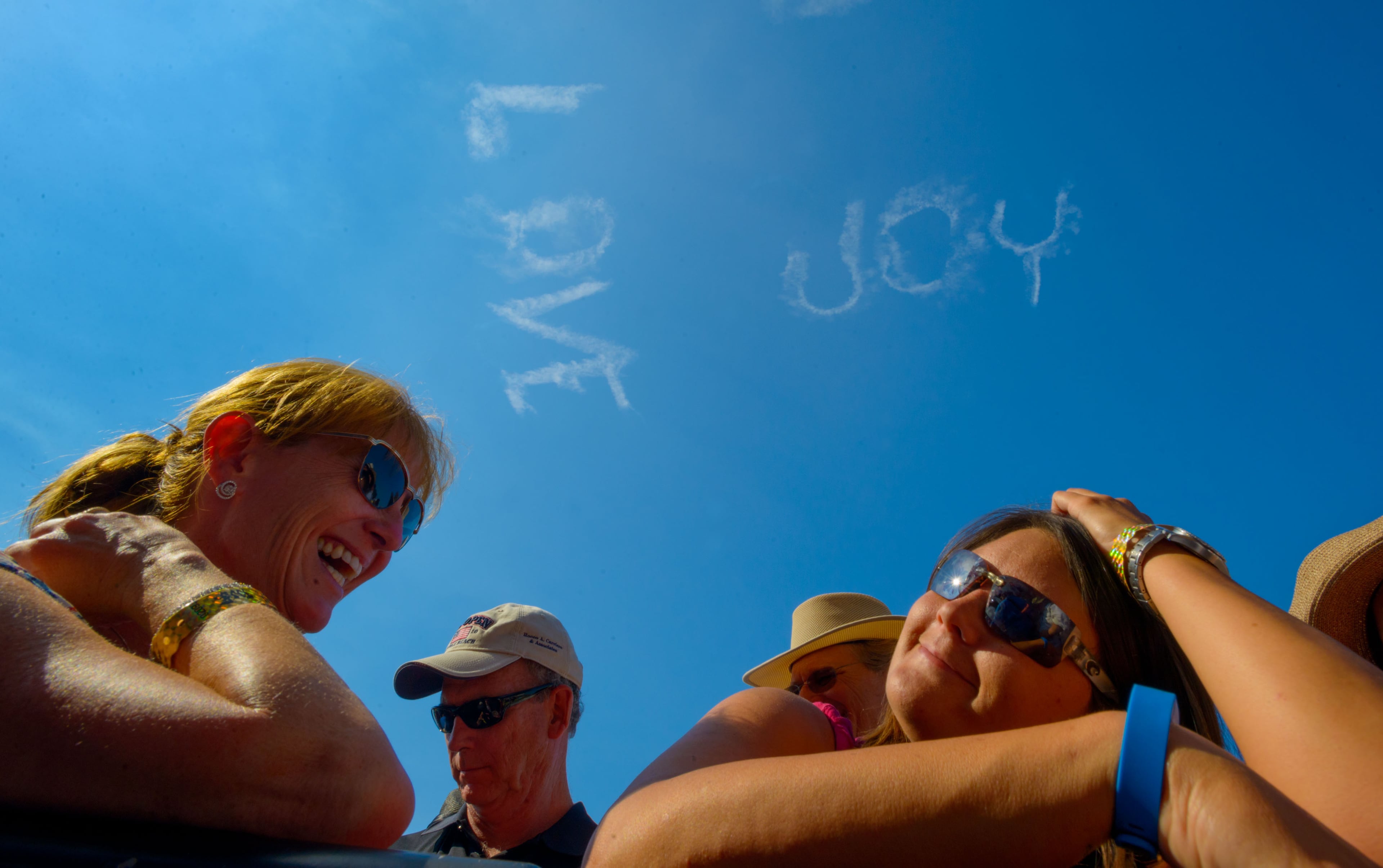 Kathy Sweeney, left, Brandi Lipsey, right, wait for Elton John after watching Jerry Lee Lewis as a sky writer makes the words "LOVE" and "JOY" on the second Saturday of Jazz Fest in New Orleans, Saturday, May 2, 2015. Lipsey is from Ferriday La., the hometown of Lewis, and Sweeney is from New Canaan, Conn. (Matthew Hinton/The Advocate via AP) MAGS OUT; INTERNET OUT; NO SALES; TV OUT; NO FORNS; LOUISIANA BUSINESS INC. OUT (INCLUDING GREATER BATON ROUGE BUSINESS REPORT, 225, 10/12, INREGISTER, LBI CUSTOM); MANDATORY CREDIT