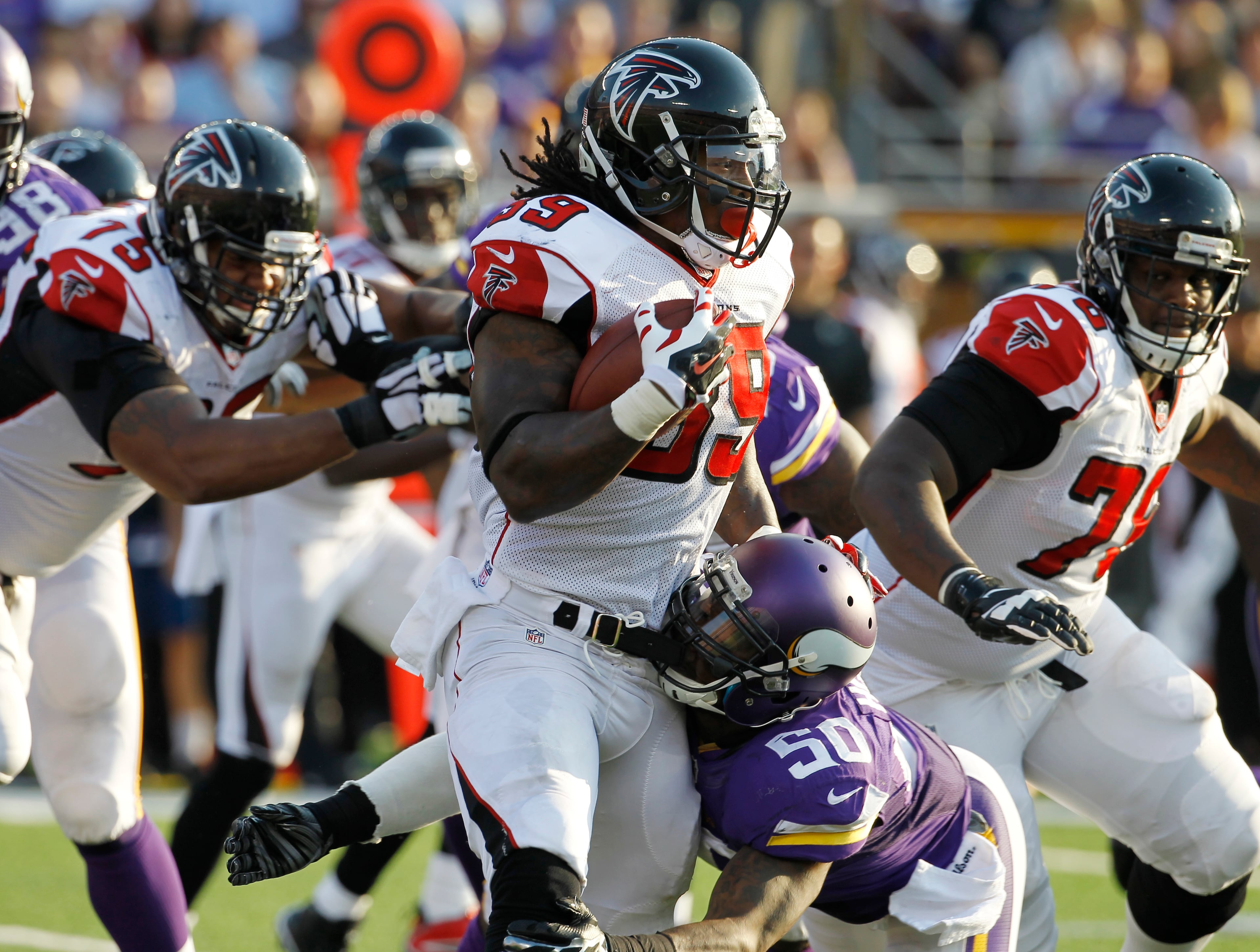 Atlanta Falcons running back Steven Jackson (39) tries to break a tackle by Minnesota Vikings outside linebacker Gerald Hodges (50) during the second half of an NFL football game, Sunday, Sept. 28, 2014, in Minneapolis. (AP Photo/Ann Heisenfelt)