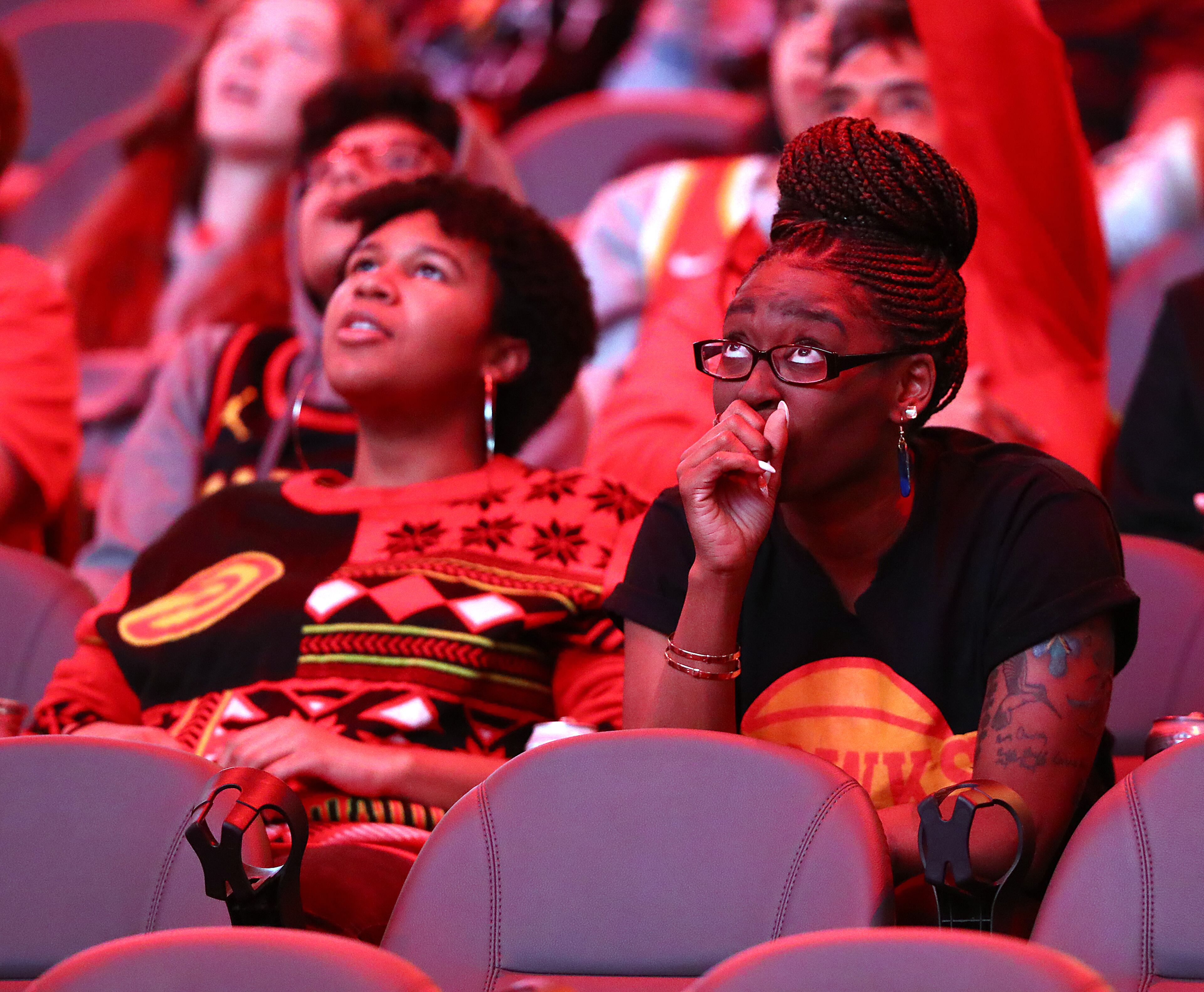041922 Atlanta: Hawks fan Kristina Johnson (right) shows a range of emotion reacting to the Miami Heat taking a lead just after cheering a Trae Young score while the Atlanta Hawks host fans at State Farm Arena during the 2022 Hawks Playoffs Watch Party for Game 2 of the NBA Eastern Conference Playoffs First Round matchup between the Atlanta Hawks and the Miami Heat on Tuesday, April 19, 2022, in Atlanta. “Curtis Compton / Curtis.Compton@ajc.com”