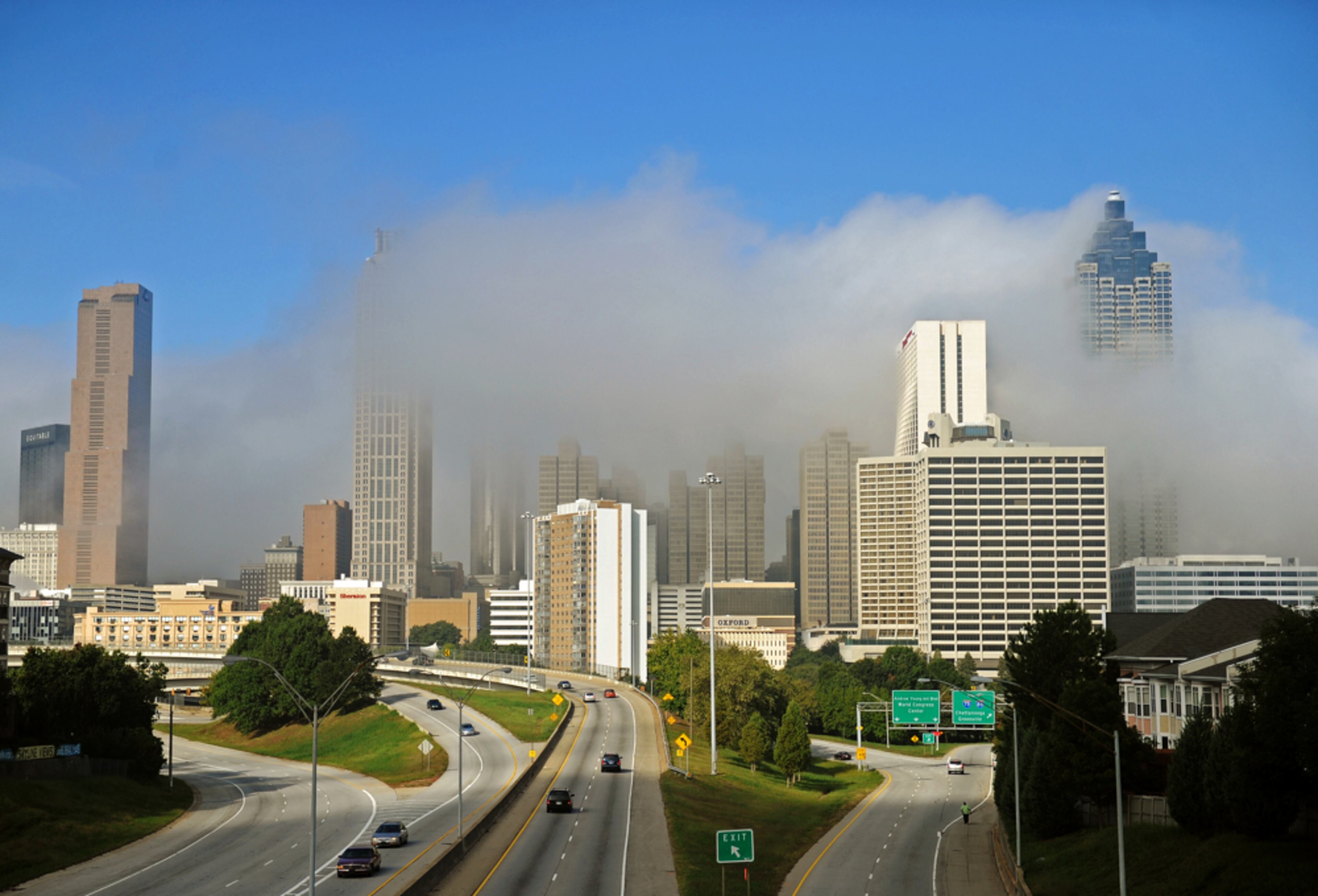 COVERED IN MIST--Oct. 3, 2012 Atlanta --A low cloud -- or leftover morning fog -- hugs the Atlanta skyline as the sun shines on a clear blue sky above as seen from the Jackson Street bridge over Freedom Parkway Wednesday, Oct. 3, 2012.