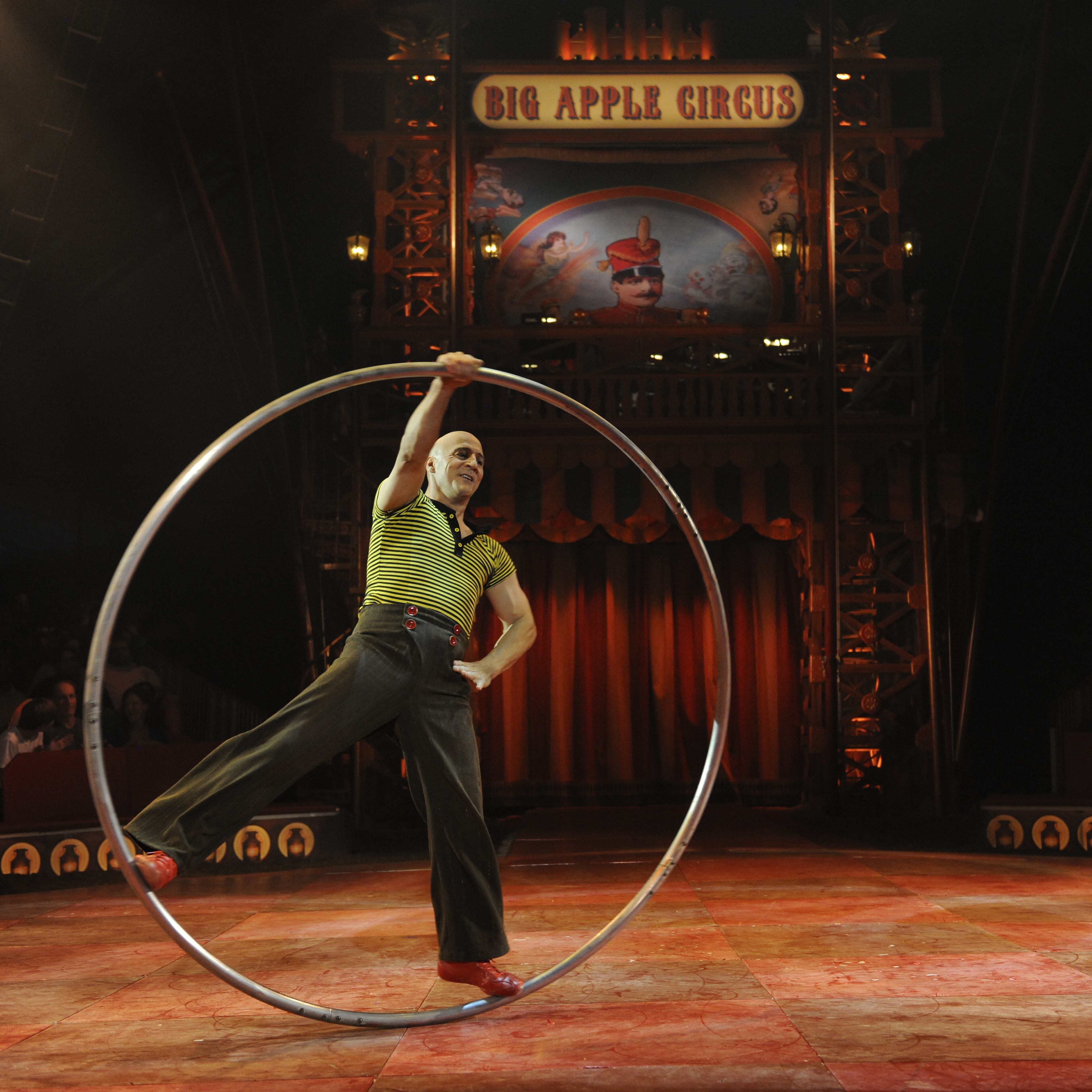 From Canada, Daniel Cyr spirals and spins around the ring in a steel hoop of his own invention.