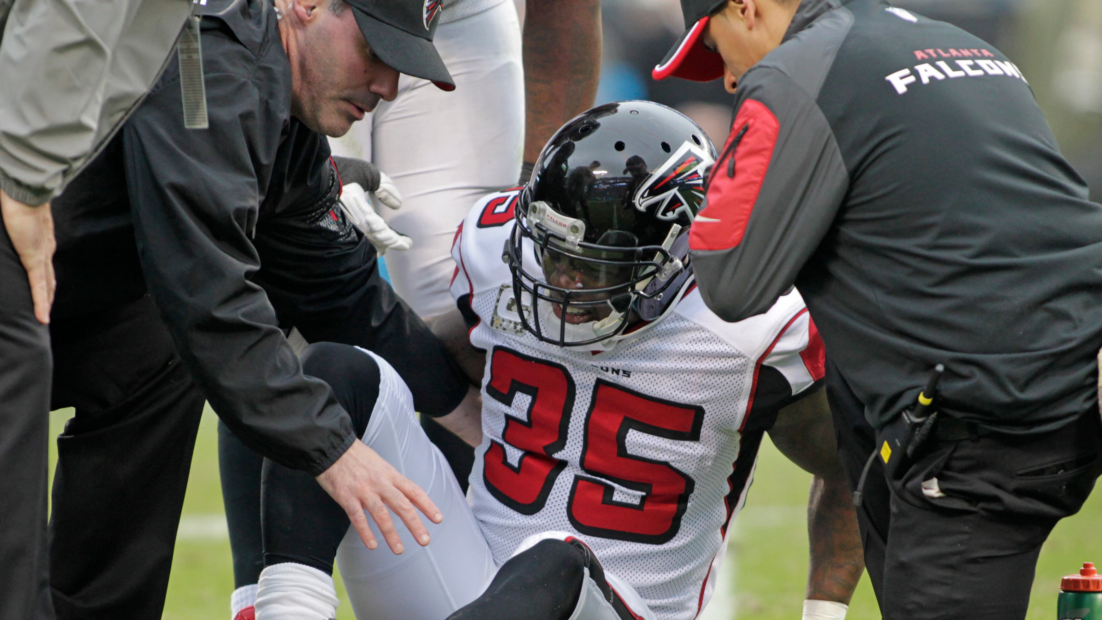 Team members assist Atlanta Falcons' Antone Smith (35) after Smith was injured in the second half of an NFL football game against the Carolina Panthers in Charlotte, N.C., Sunday, Nov. 16, 2014. (AP Photo/Bob Leverone)