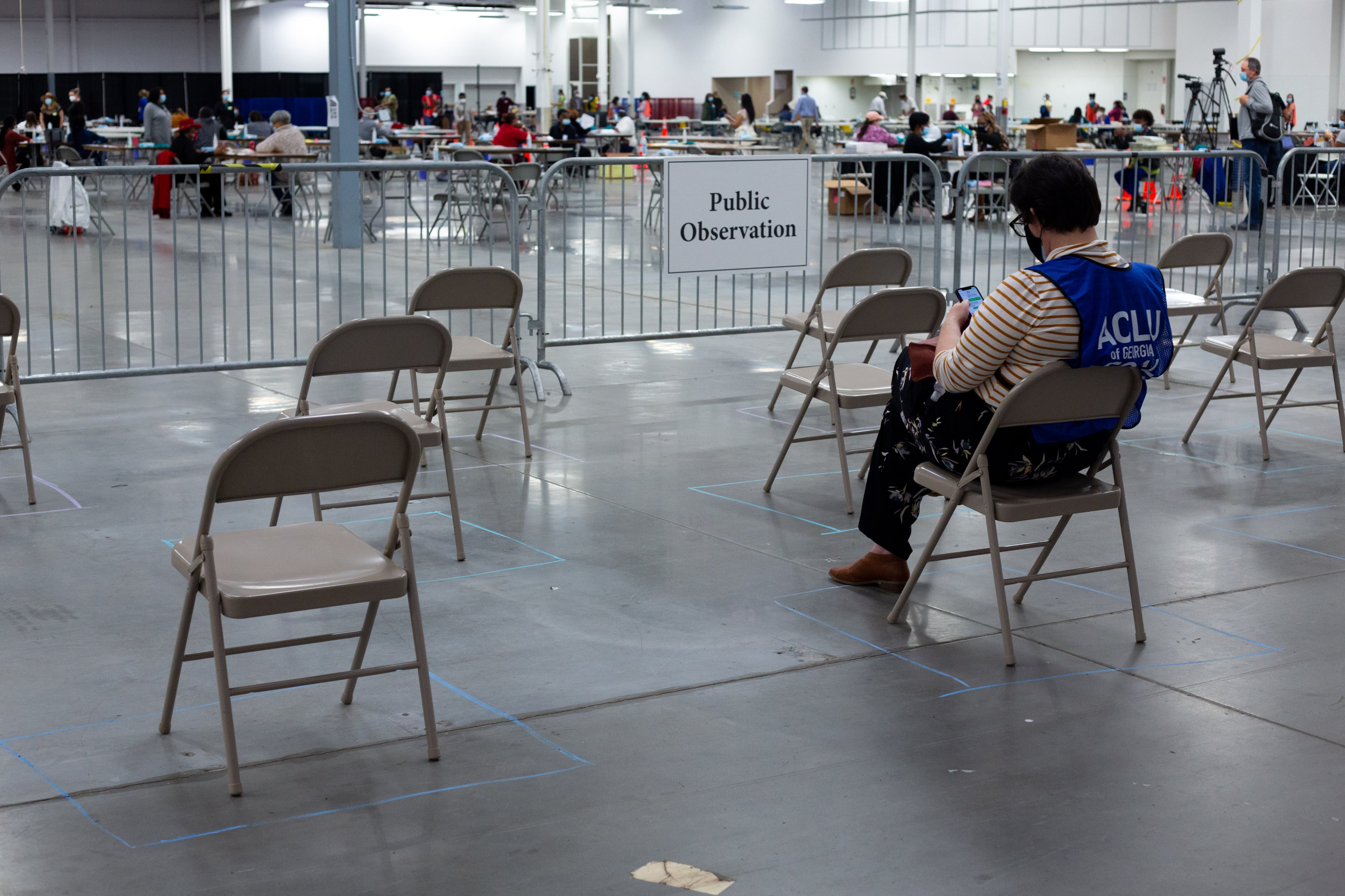 A legal observer from the ACLU of Georgia watches as people recount ballots from the 2020 presidential election on Sunday, Nov. 15, 2020, in Stonecrest, Georgia. (Rebecca Wright for the Atlanta Journal-Constitution)