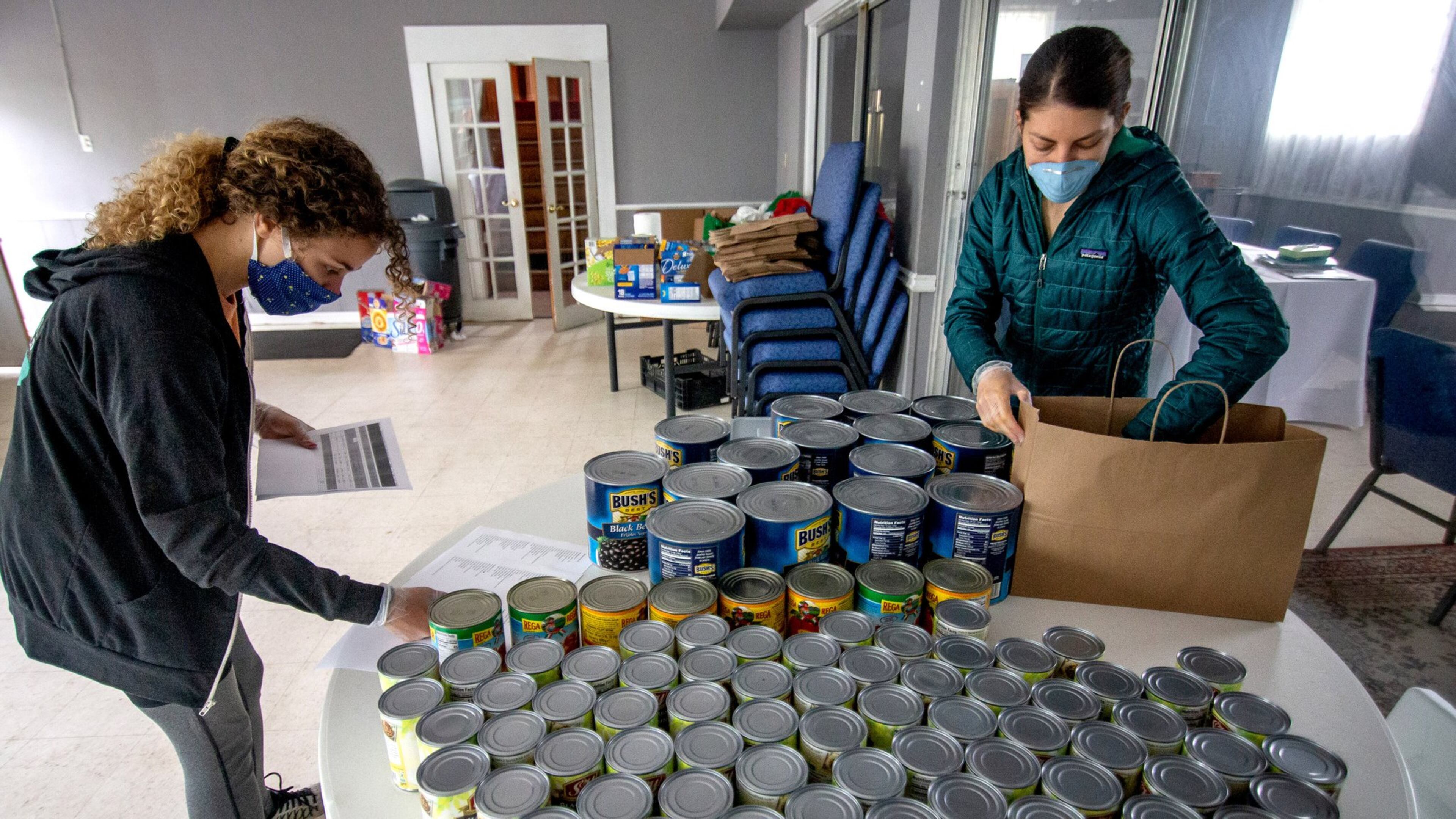 Concrete Jungle volunteers Cecelia Borgman (L) and Savannah Schnall (R) organize meals that will be delivered to Atlanta needy families Monday, April 20, 2020. STEVE SCHAEFER / SPECIAL TO THE AJC