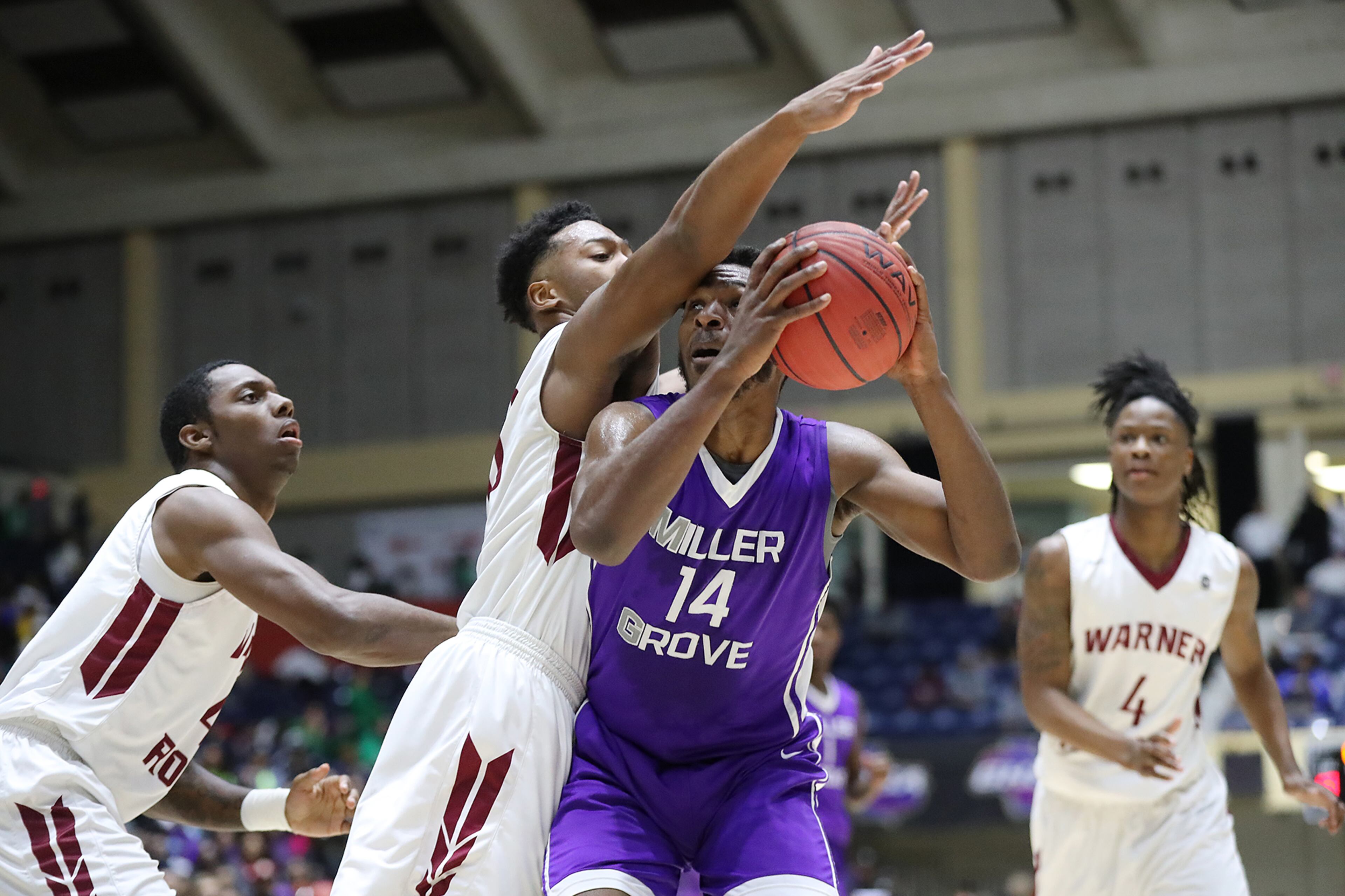 March 8, 2018 Macon: Miller Grove forward Jermon Clark battles against three Warner Robins defenders looking to shoot in their GHSA state basketball championship game on Thursday, March 8, 2018, in Macon. Curtis Compton/ccompton@ajc.com