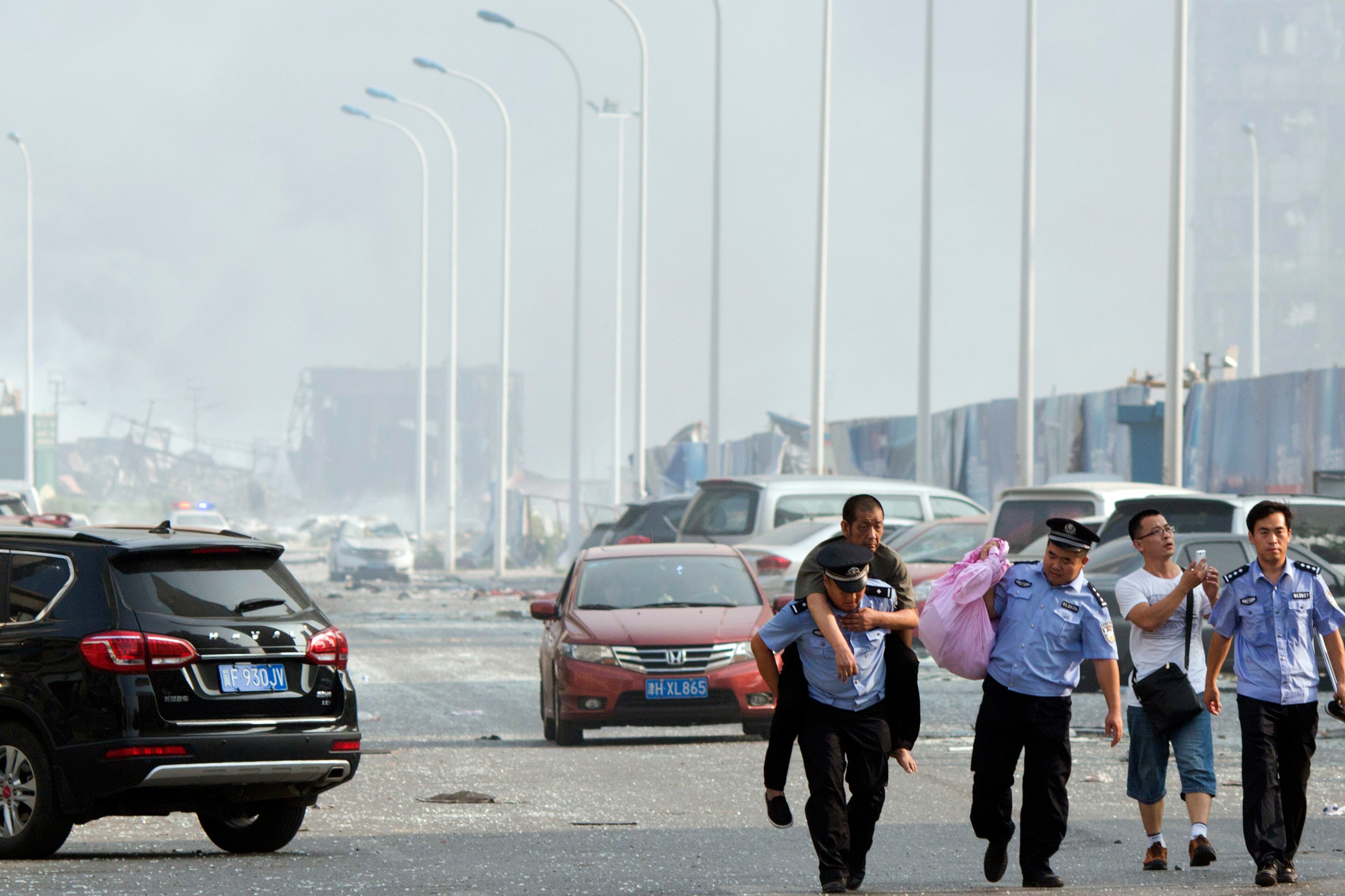 Chinese police help a man to safety near the site of an explosion in northeastern China's Tianjin municipality Aug. 13, 2015. Chinese state media reported huge explosions at the Tianjin port late Wednesday.
