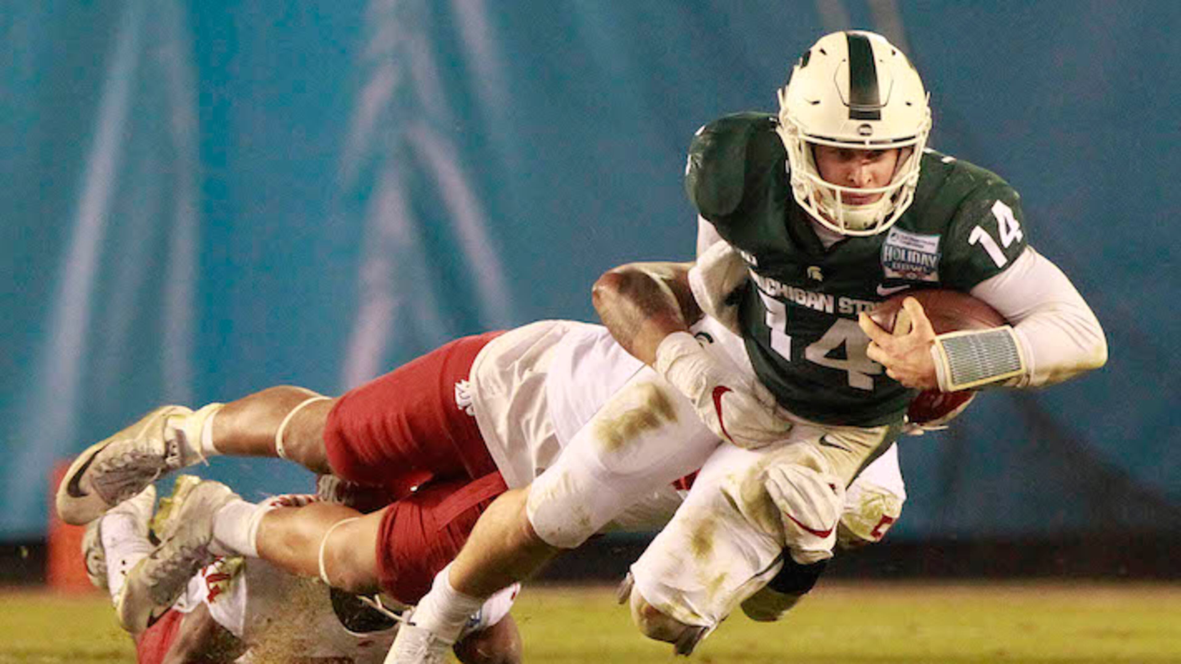 Michigan State quarterback Brian Lewerke (14) is tackled by Washington State's Frankie Luvu as Lewerke runs the ball in the second quarter of the Holiday Bowl at SDCCU Stadium in San Diego on Thursday, Dec. 28, 2017. (Hayne Palmour IV/San Diego Union-Tribune/TNS)