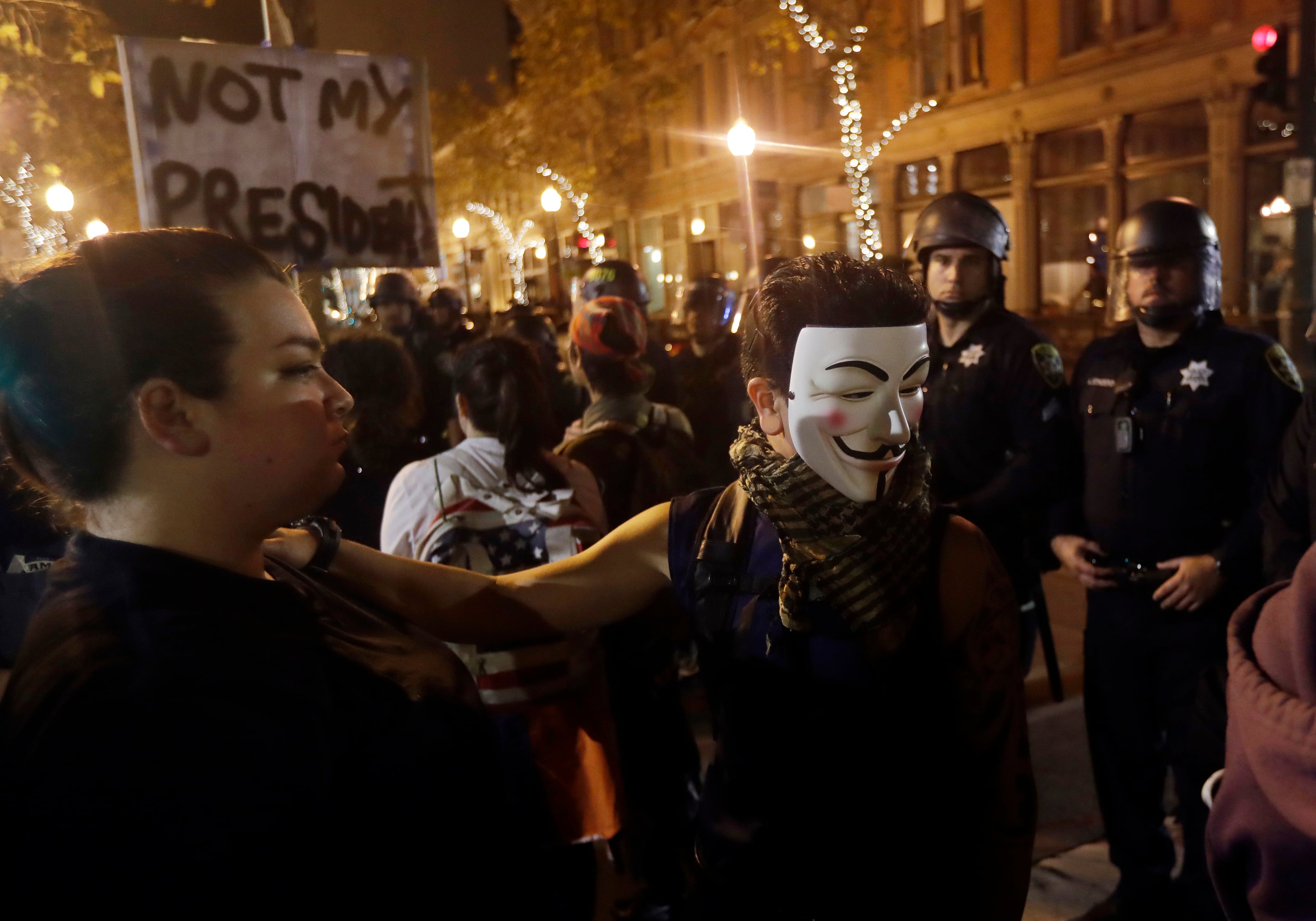 Protesters stand in front of a police line Wednesday, Nov. 9, 2016, in Oakland, Calif. Police in Oakland blocked thousands of people protesting Donald Trump's election from getting onto a highway Wednesday night. The crowd chanting and waving signs gathered in Frank Ogawa Plaza in downtown Oakland in the afternoon. (AP Photo/Marcio Jose Sanchez)