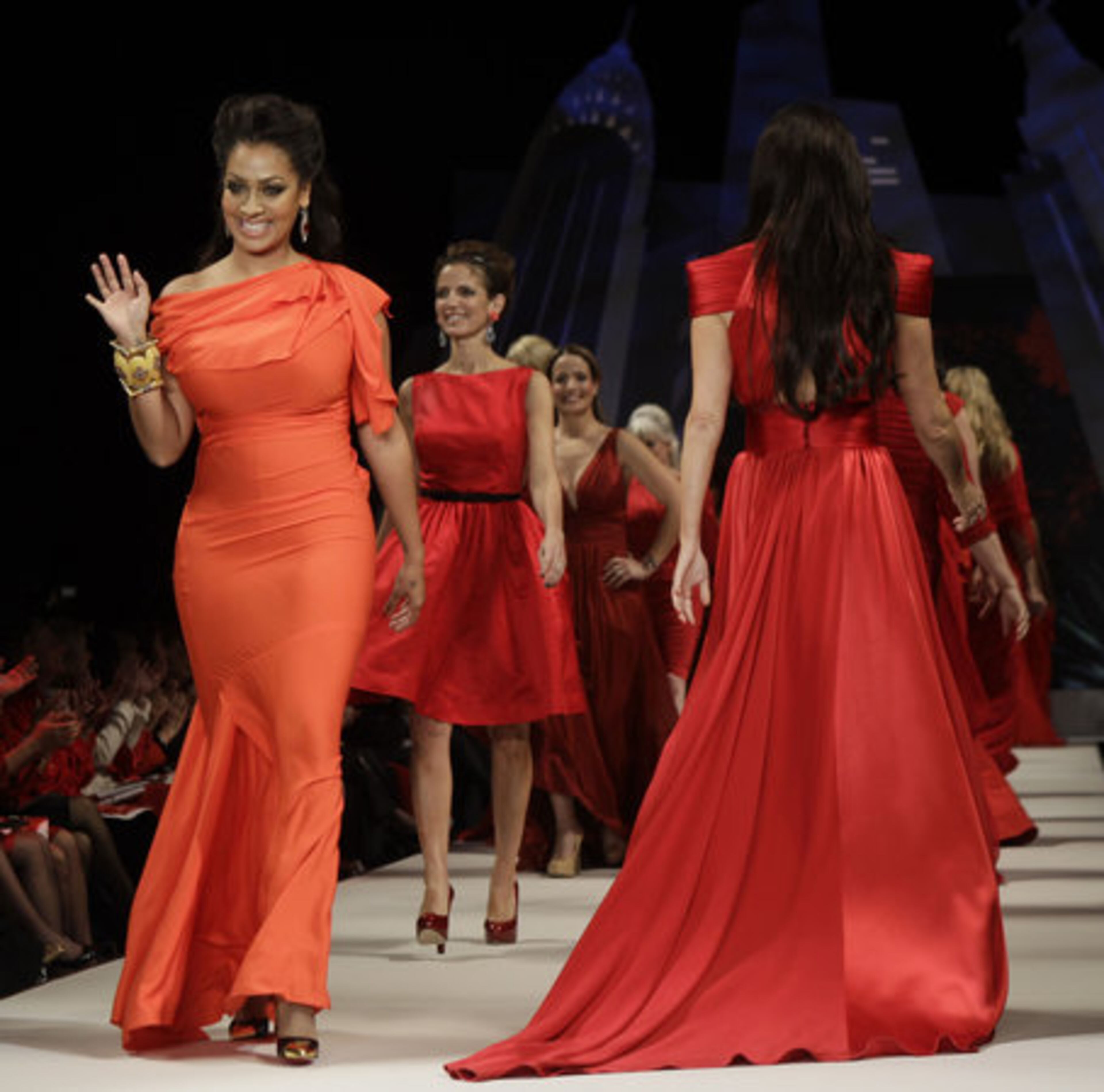 LaLa Anthony, left, wife of New York Knicks basketball player Carmelo Anthony, waves as she models Rachel Roy.