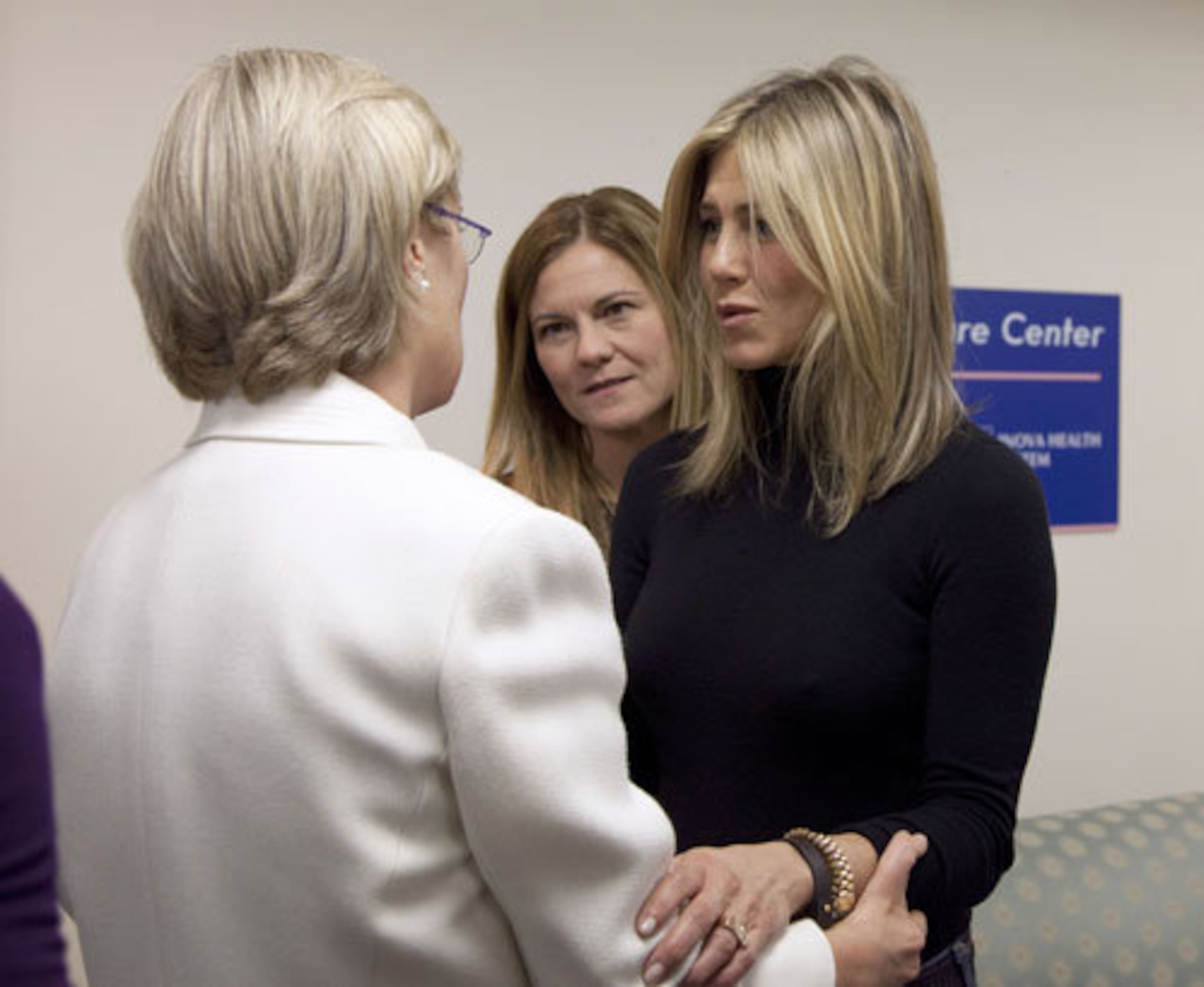 "Five" producer Kristin Hahn, center, and Jennifer Aniston, talk with a breast cancer survivor at the Inova Breast Care Center.
