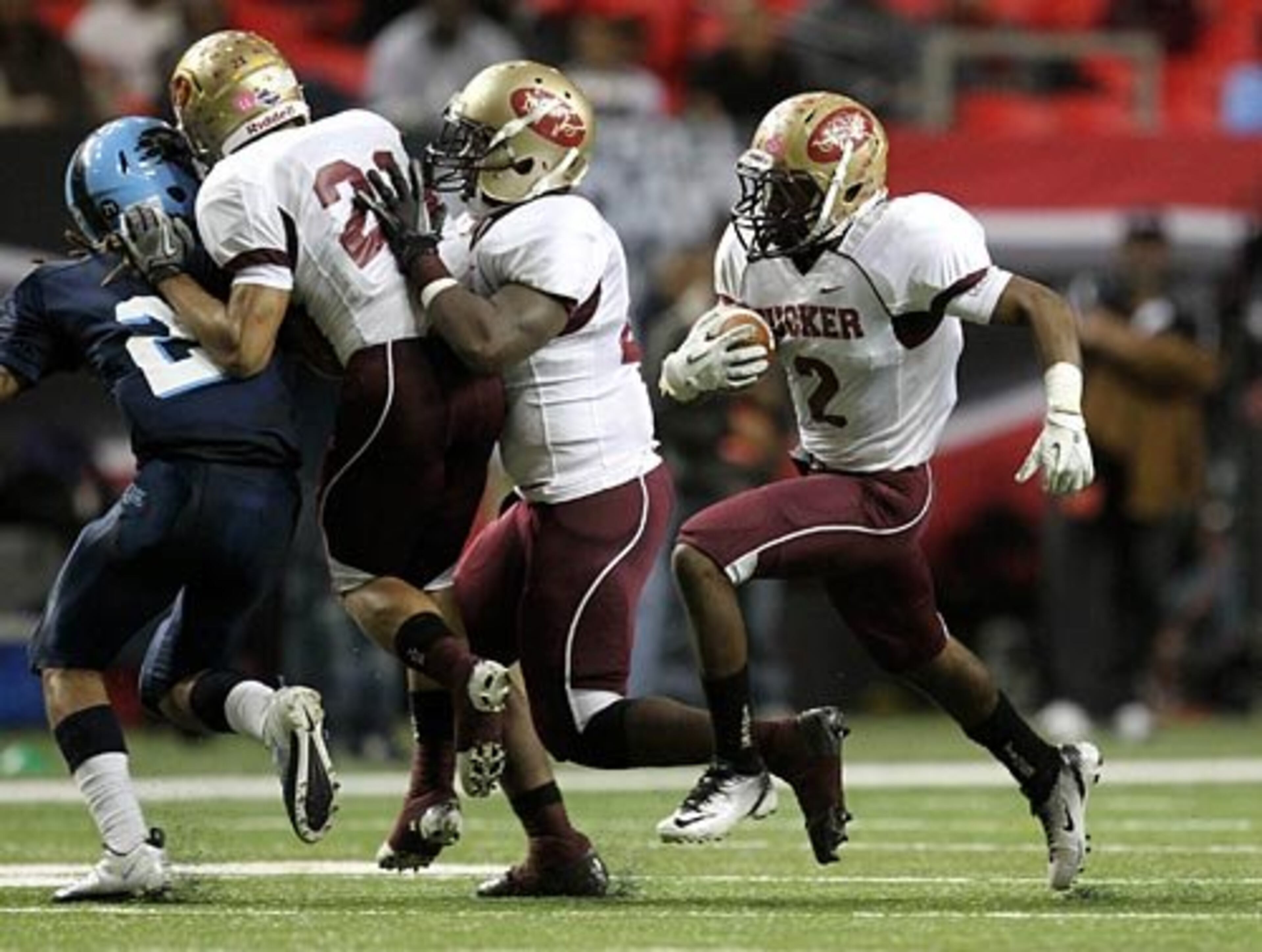 Tucker running back Yusuf Minor (2) gets some blocks from teammates as he runs for a first half touchdown.