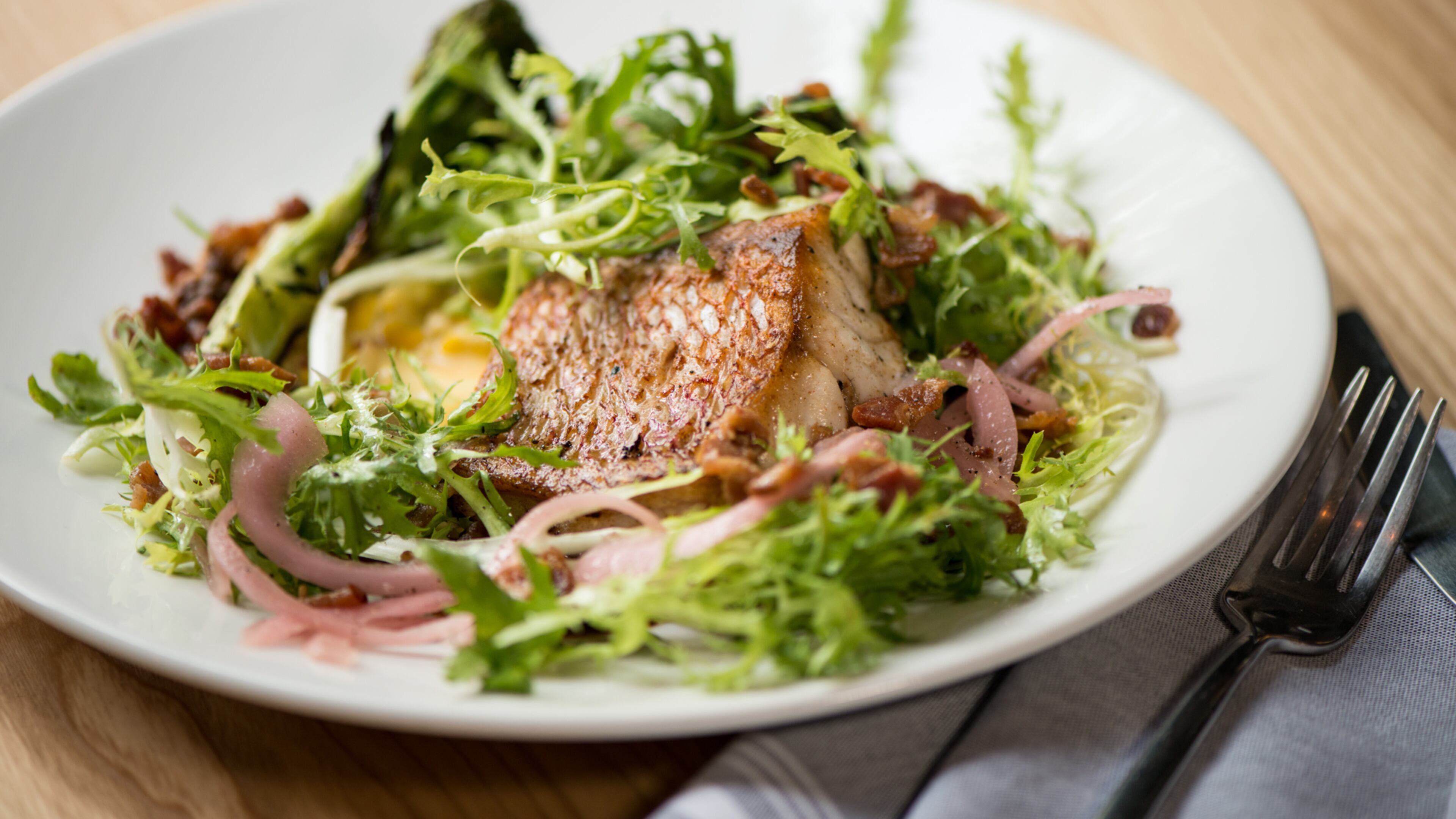 Cast Iron wild caught snapper, creamy corn, grilled broccoli, lentils, frisee, bacon, pickled onion. Photo credit- Mia Yakel.