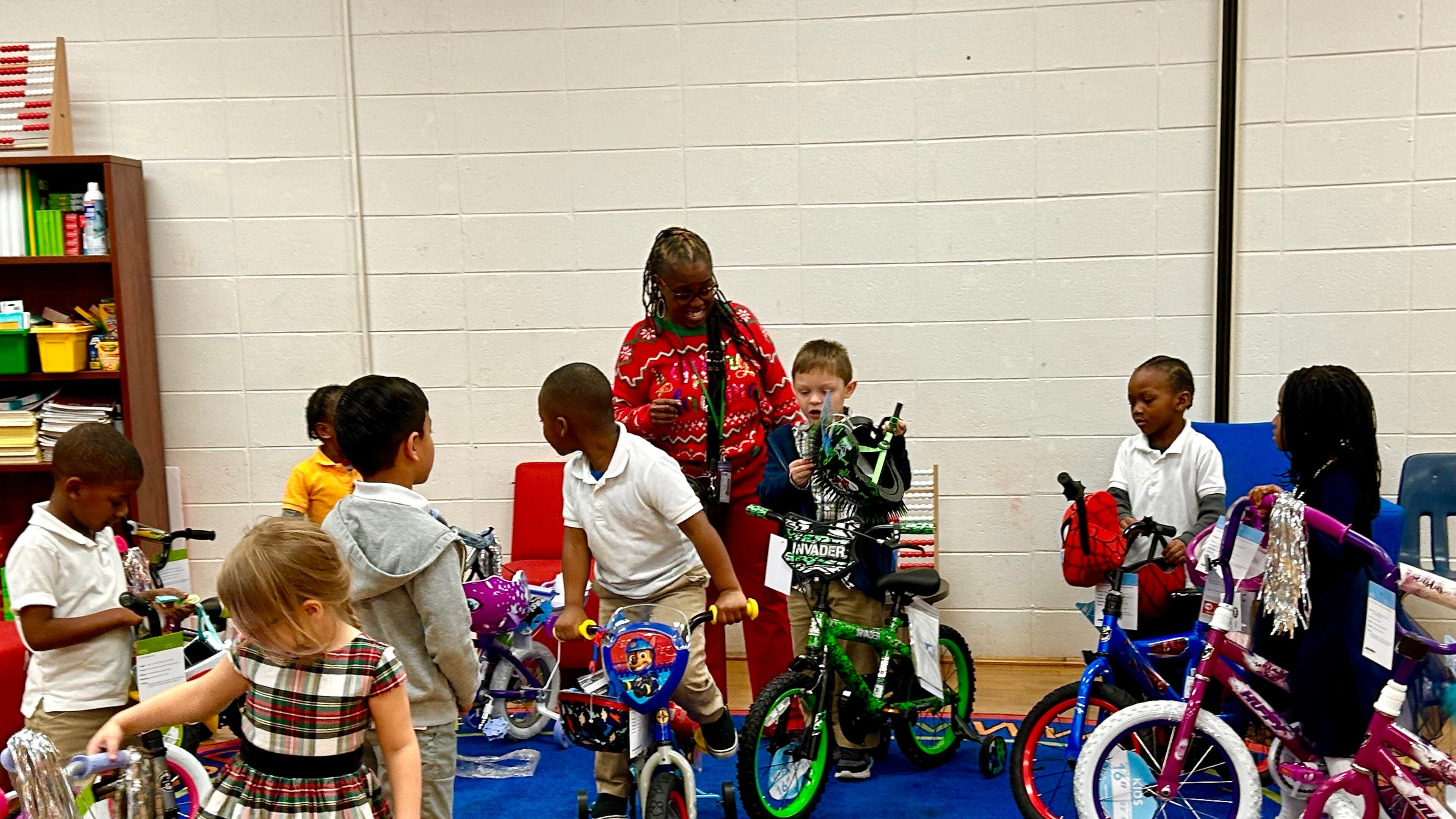 Early Learning Center at Henderson E. Formey School Principal, Erica Swindell-Foster helps Pre-K and Kindergarten students test out donated bikes from Gateway Terminals on Thursday Dec. 14, 2023