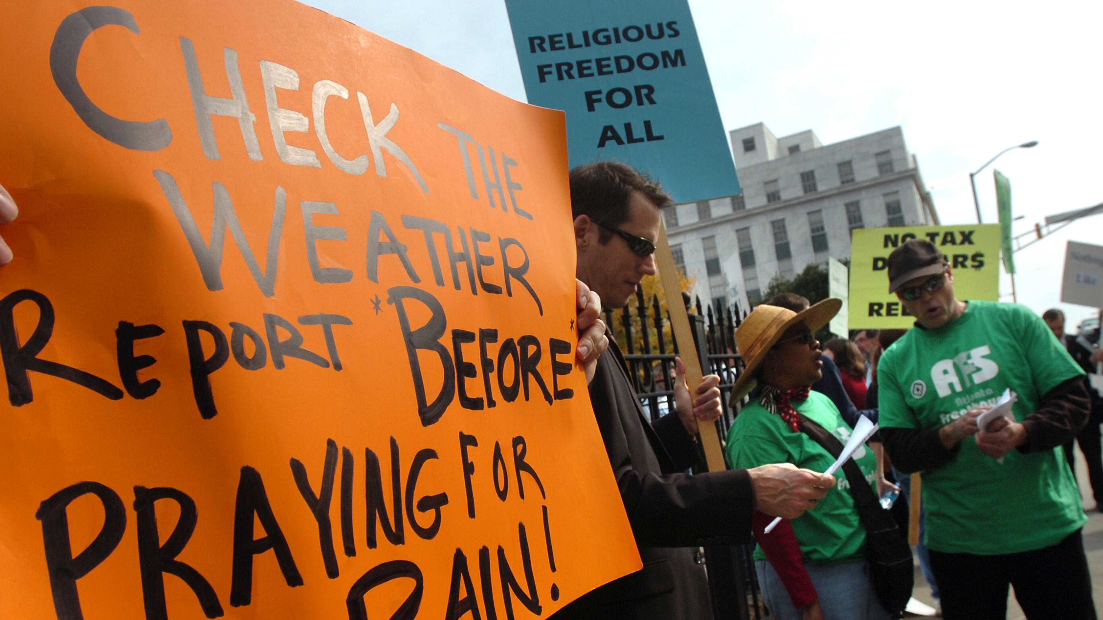 Protesters from Atlanta Freethought Society hold signs before "Prayer Service for Rain" starts outside The Georgia State Capitol in Atlanta. Gov. Sonny Perdue holds a prayer service for rain Tuesday at 11:45 a.m. Tuesday, November 13, 2007. (HYOSUB SHIN / Staff)