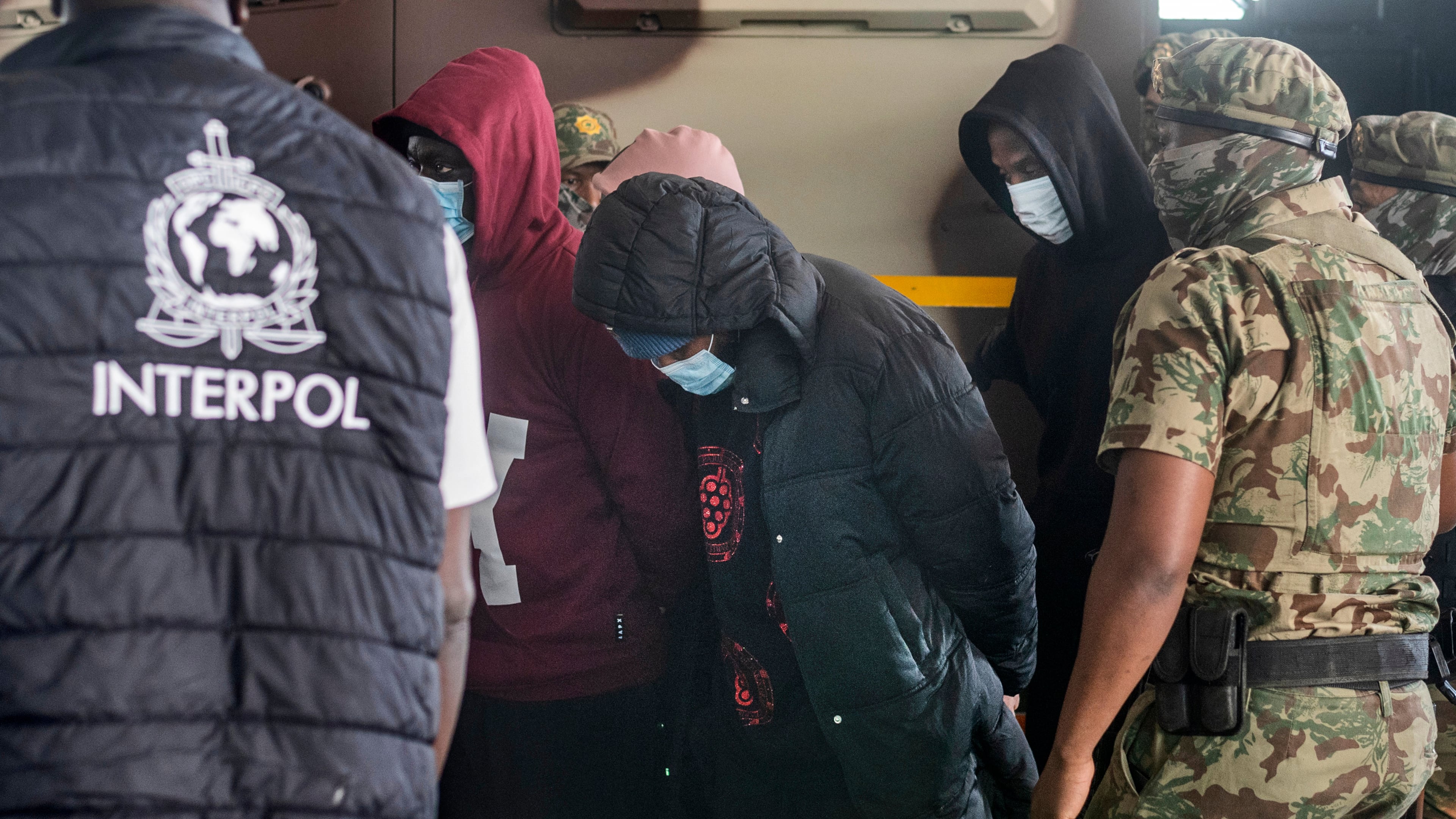 Members of the elite tactical police unit escort six Nigerians nationals being extradited to US for participating in romance scams, in Cape Town, South Africa, Friday, Sept. 11, 2026. (AP Photo)